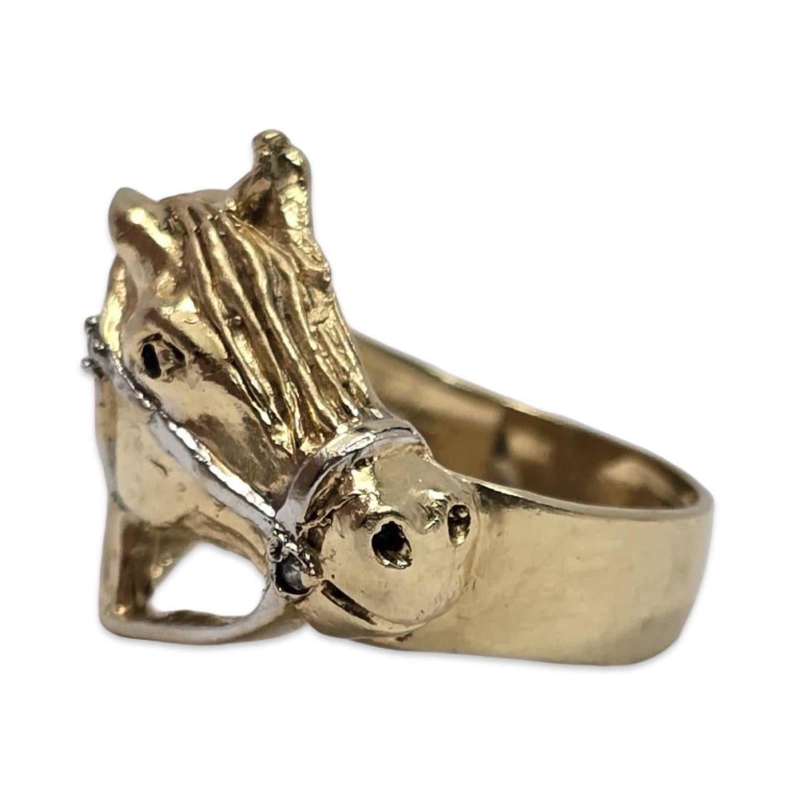 Un tesoro equestre con un tocco di scintillio: questo anello con testa di cavallo finemente scolpita è realizzato in oro giallo 14K con dettagli a briglia in oro bianco, accentati da un diamante naturale rotondo per una maggiore brillantezza.

Con