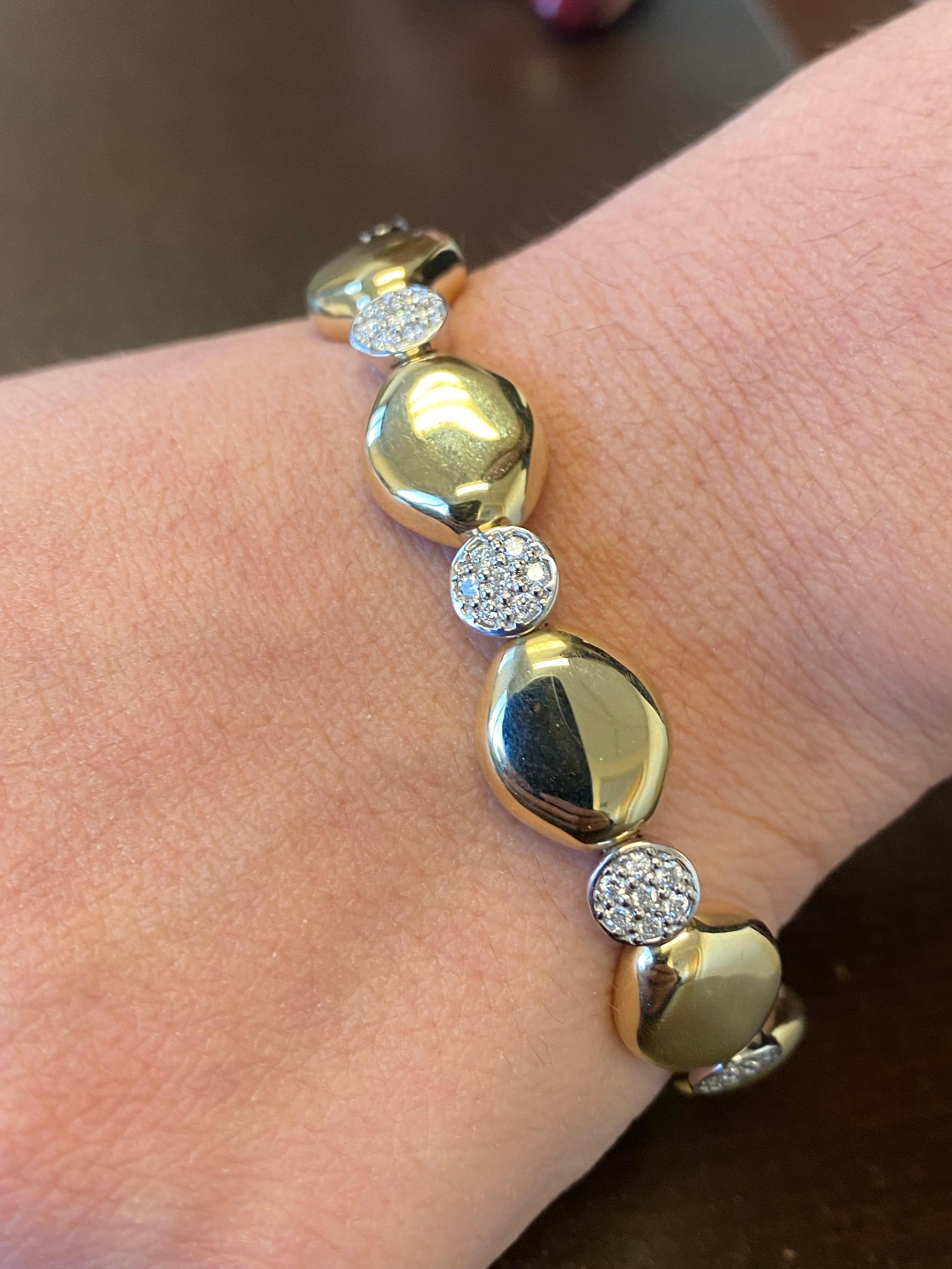 Italian made bangle set in a 2 tone white and yellow gold 14K. The bangle is set with 35 stones, total carat weight is 0.70 carats. The color of the stones are G-H, the clarity is SI1-SI2.