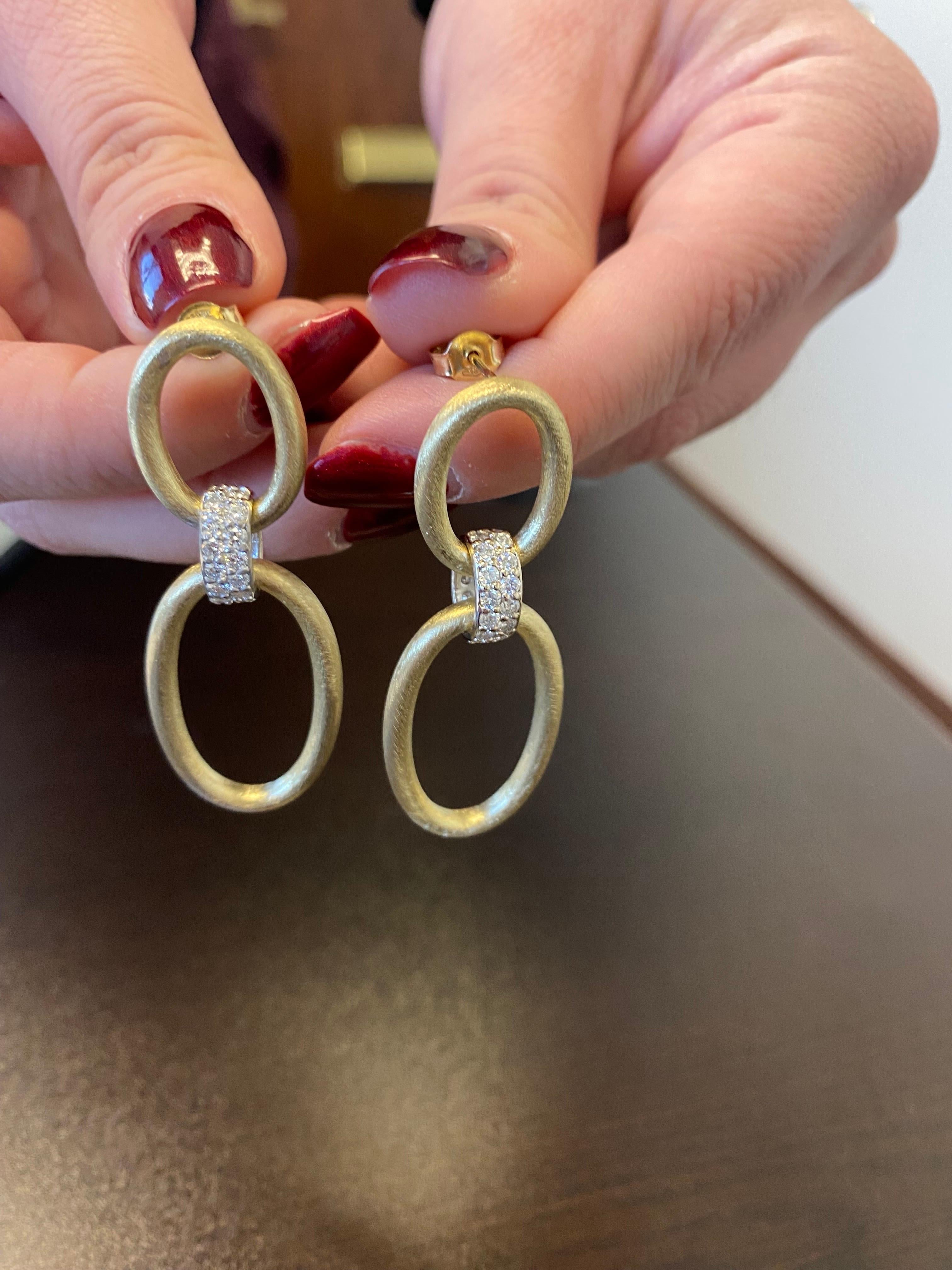 Diamond dangling set earrings set in 14K yellow and white gold 2 tone. The earrings are done in a Matte yellow gold finish. The total carat weight is 1.50. Color of the stones are G, the clarity is SI1-SI2. The earrings are manufactured in Italy.