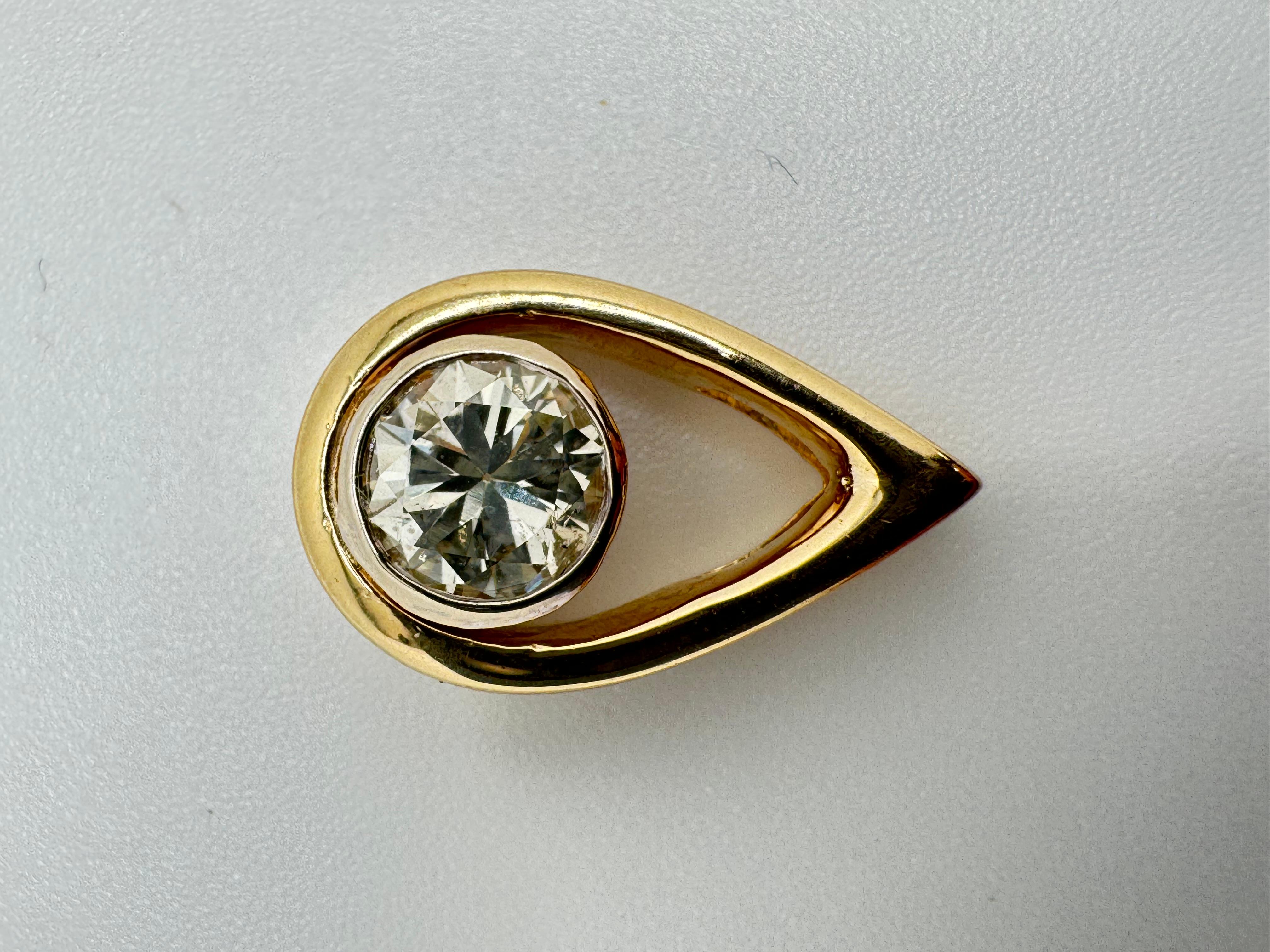 Realizzato in radioso oro giallo 14K, questo elegante ciondolo presenta un design moderno e artistico evidenziato da un diamante brillante incastonato al centro. Il diamante ha un peso totale di circa 1,20 carati e conferisce al pezzo un'incredibile