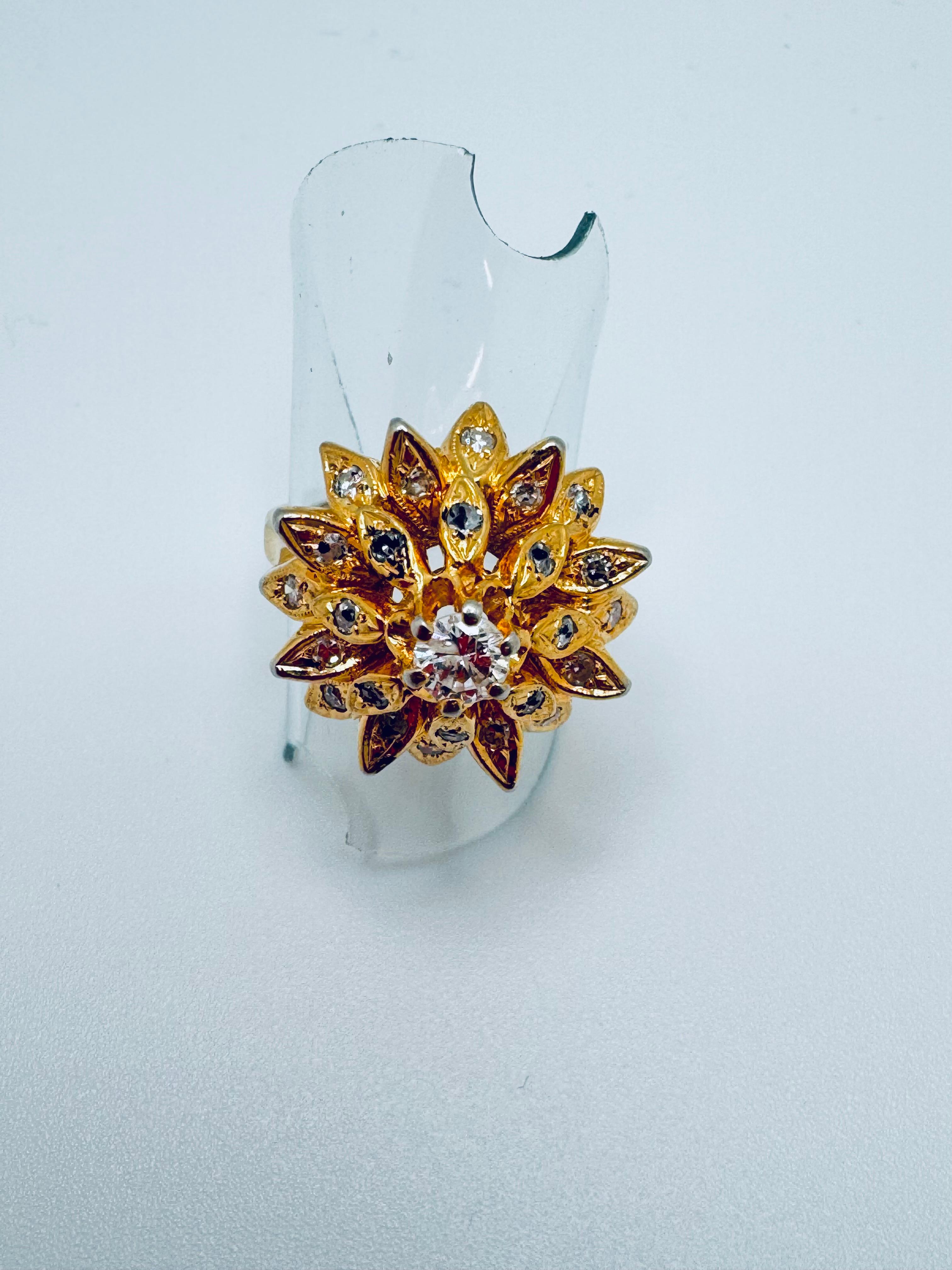 Dieser elegante Blumenring aus 14 Karat Gelbgold zeichnet sich durch ein strahlendes Blumendesign aus, das mit funkelnden Diamanten besetzt ist. In seiner Mitte befindet sich ein einzelner runder Diamant von ca. 0,38 mm Durchmesser und einem
