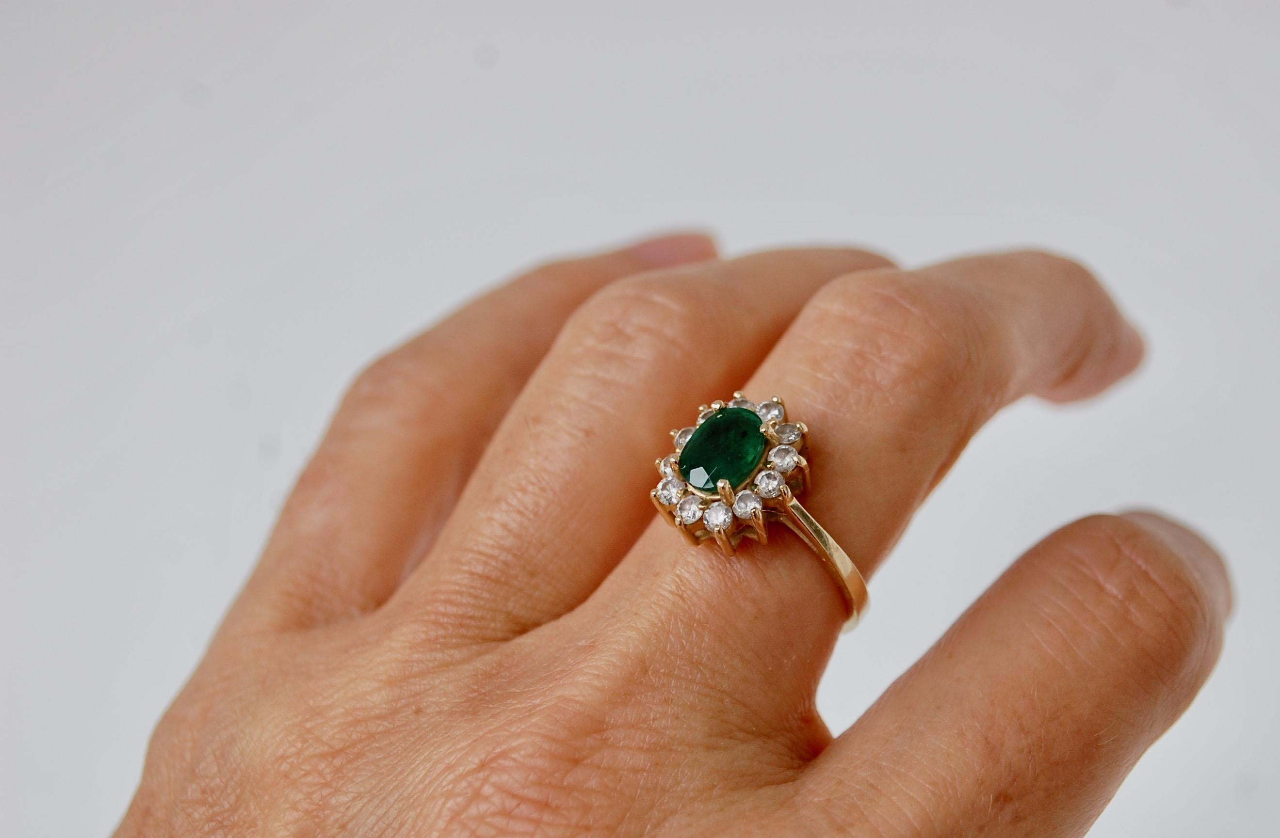 14KG Emerald And Diamond Cocktail Ring
Beautiful vintage 14k yellow gold Princess Di style cocktail deep green emerald and diamond ring.  Mounting with an oval faceted green emerald center of approximately 1.25 carats. Surrounded by a halo of round