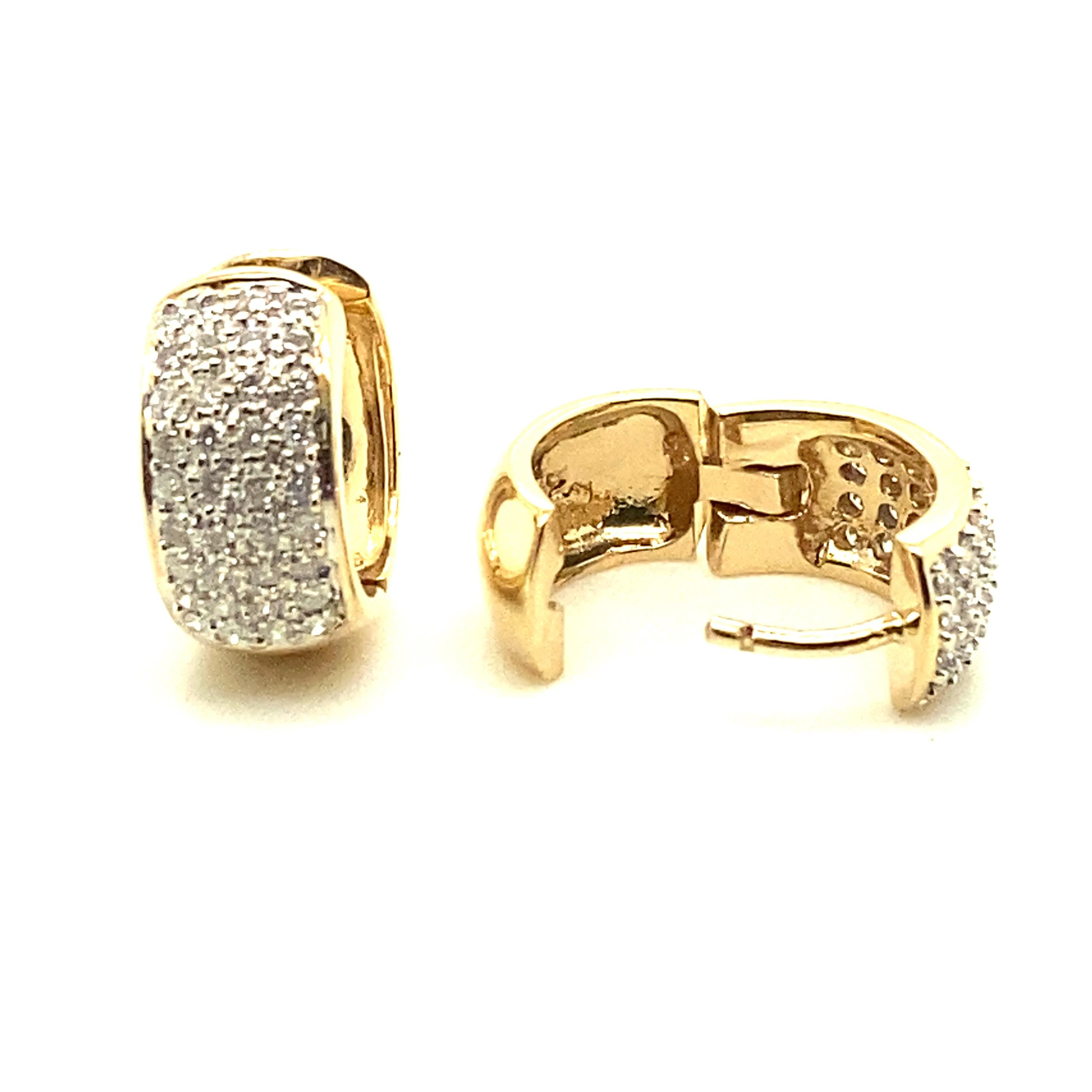 14kt yellow gold .75 total carat pave' set diamond earrings. The earrings are huggie style so it looks like one continuous loop from your earlobe. The earrings measure 14.25mm high (just over .50 inch) by 7.03mm (just over .25 inches) wide. The