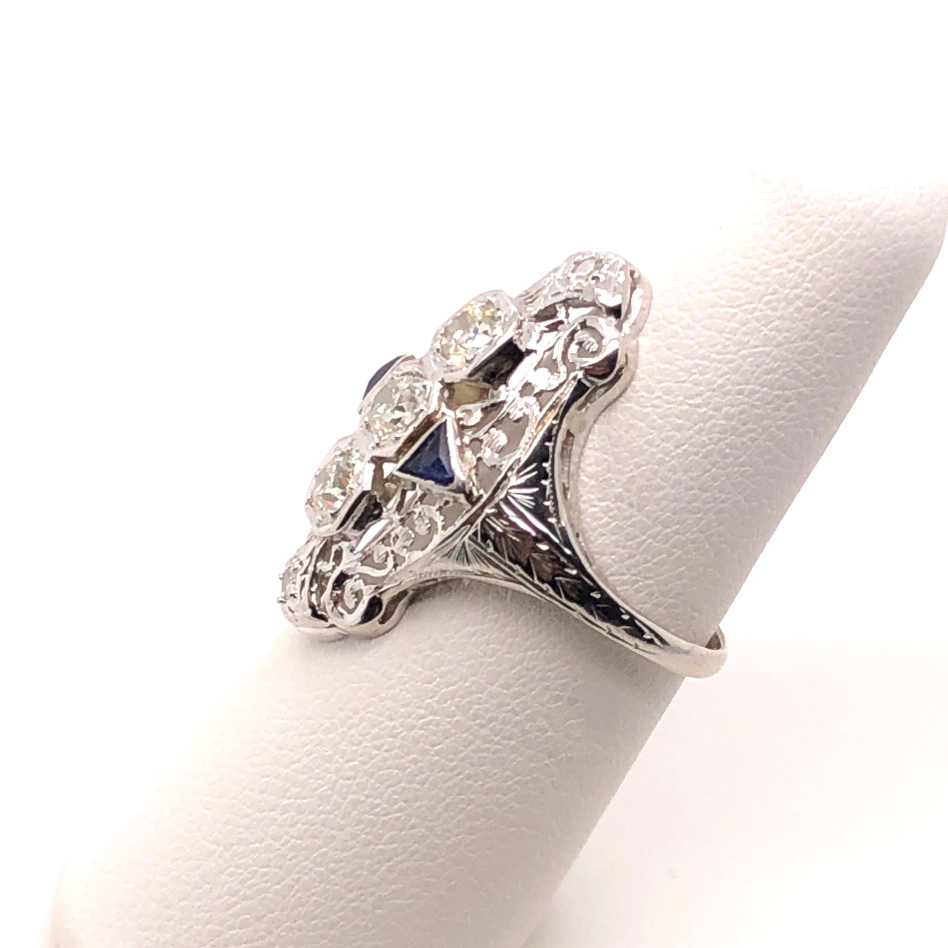 Original Art Deco ring from the 1920's. A total Flapper ring if ever there was one! This ring features .75 carats of Old European Cut Diamonds and two triangular cut created sapphires on the sides. Did you know that most original Art Deco jewelry