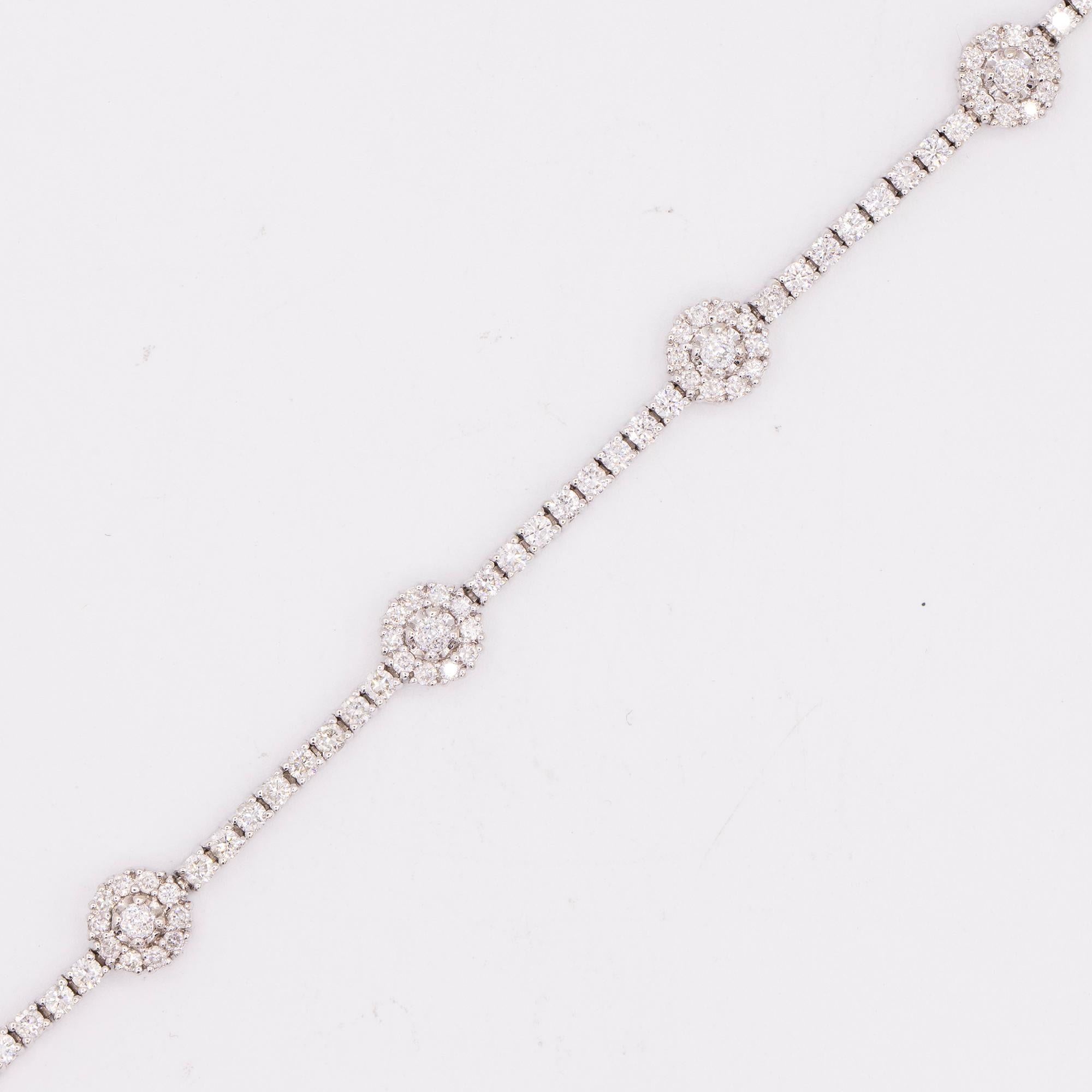Vintage 14kt diamond station bracelet with 6 flower design stations. The bracelet measures 7.25 inches in length with a safety clasp. There are 115 round brilliant cut diamonds that have a total weight of 2.55 carats. There are 6 bead cut faceted