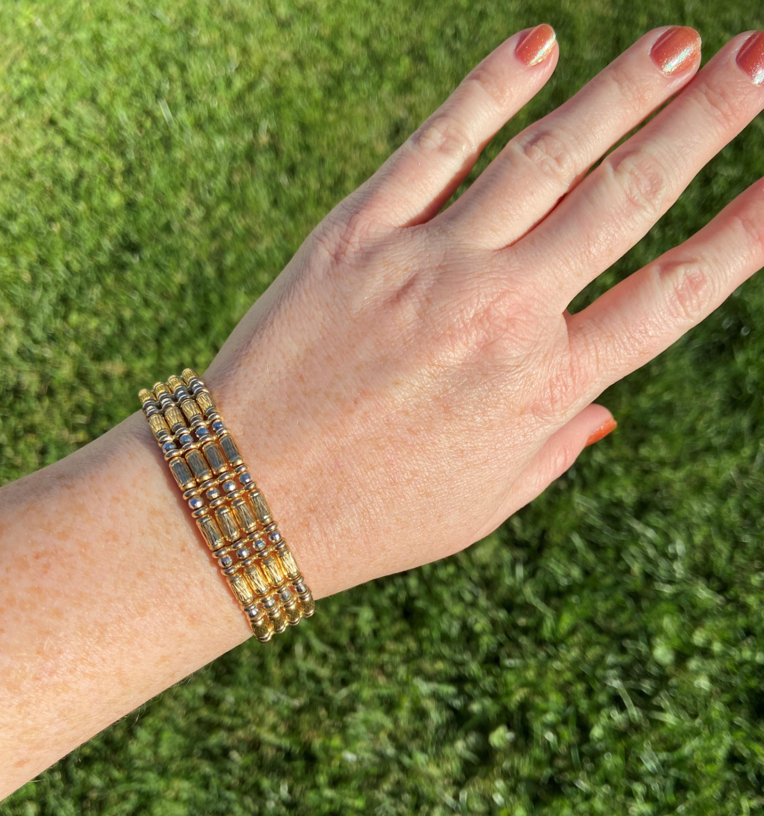14kt yellow and white gold cuff featuring four rows of textured and faceted beads. The cuff is flexible with an approximate circumference of 7.5 inches. The cuff measures approximately 14.1 mm wide. 

Stamped 