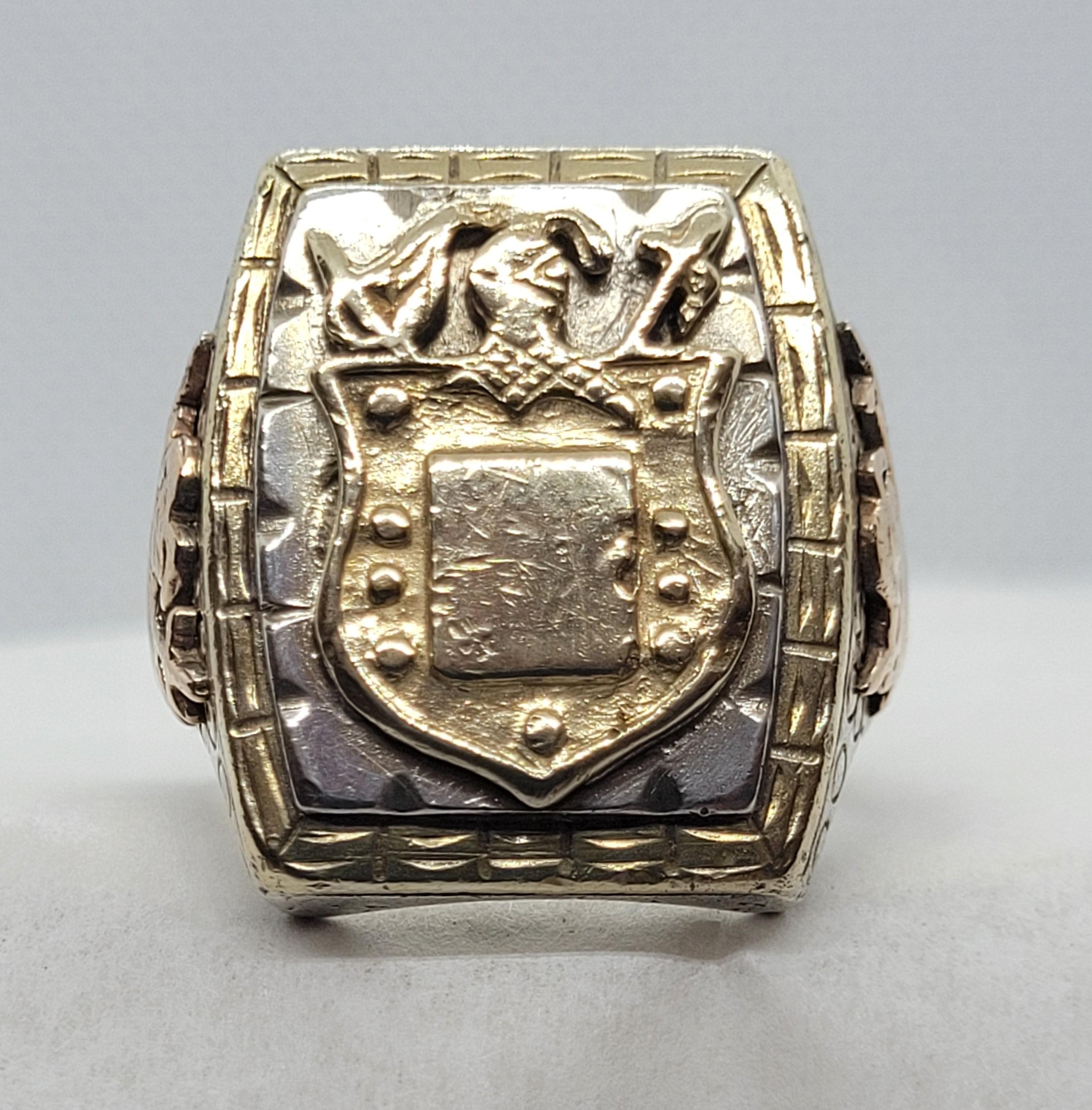 Unique men's crest ring that is silver and two-tone copper and brass. This heavy ring has a detailed crest shield design that has a space for personalized engraving; 24mm x 20mm in diameter on the face of the ring. The ring is 30 grams, size 10,