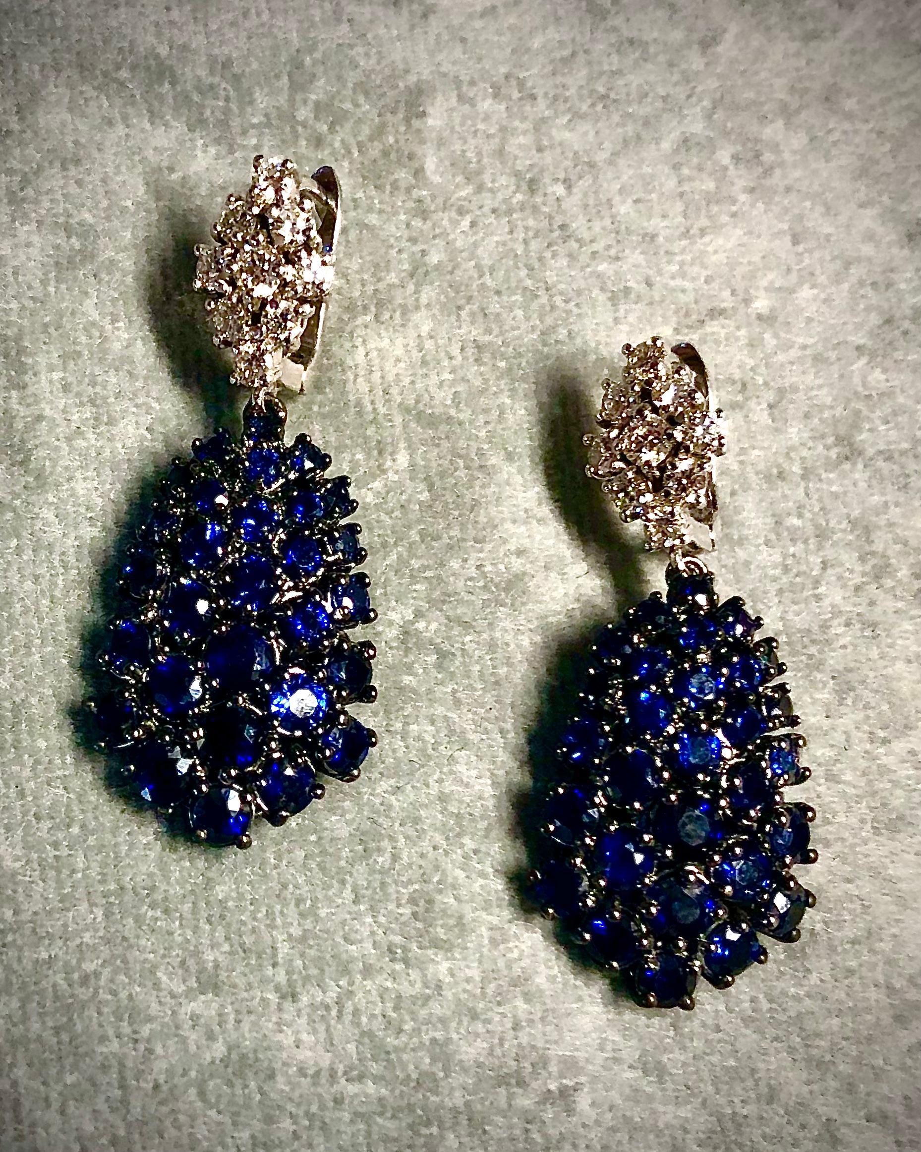 A lovely pair of elegant 14kt. gold diamond and round cut brilliant deep blue sapphire earrings.  The teardrop 7.04 cts. of sapphire embellished pendants are surmounted by diamond elongated diamond shaped rectangle formed with 0.72 CTs. of sparkling