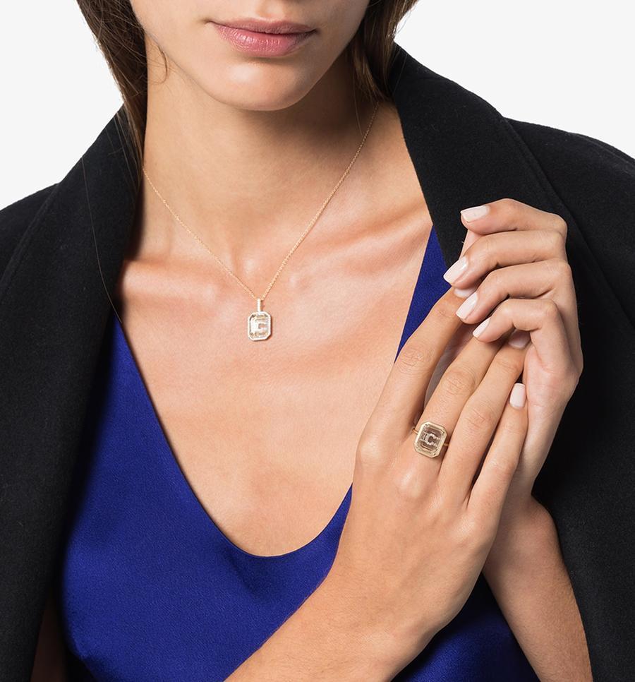 Beautifully handcrafted in New York of solid 14K Yellow Gold set with our special emerald cut crystal quartz. The personalized diamond pave initial is then set/hidden underneath the gemstone.