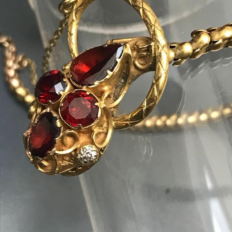 Ce magnifique bracelet serpent antique est en or massif 14kt et présente des grenats facettés le long du corps du serpent, avec de petits diamants sertis pour ses yeux. Datant de l'époque victorienne, il s'agit d'une pièce finement ouvragée aux