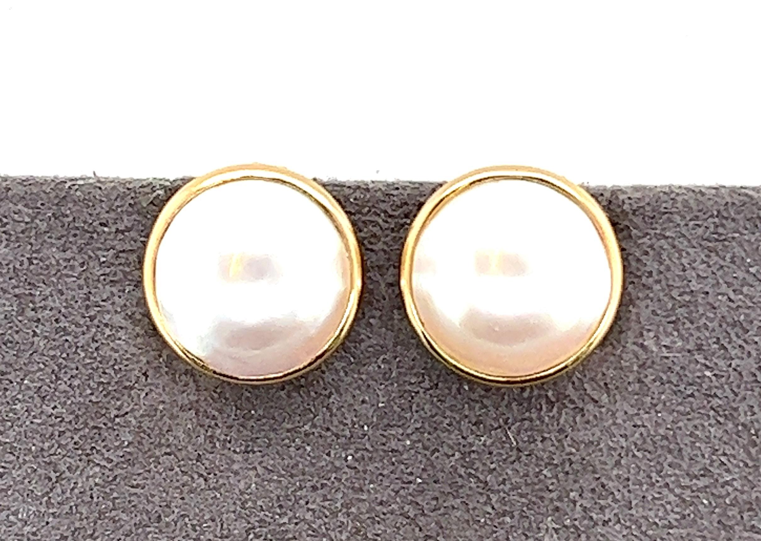 14kt yellow gold Mabe' Pearl button style clip on earrings. 
The earrings measure 5/8