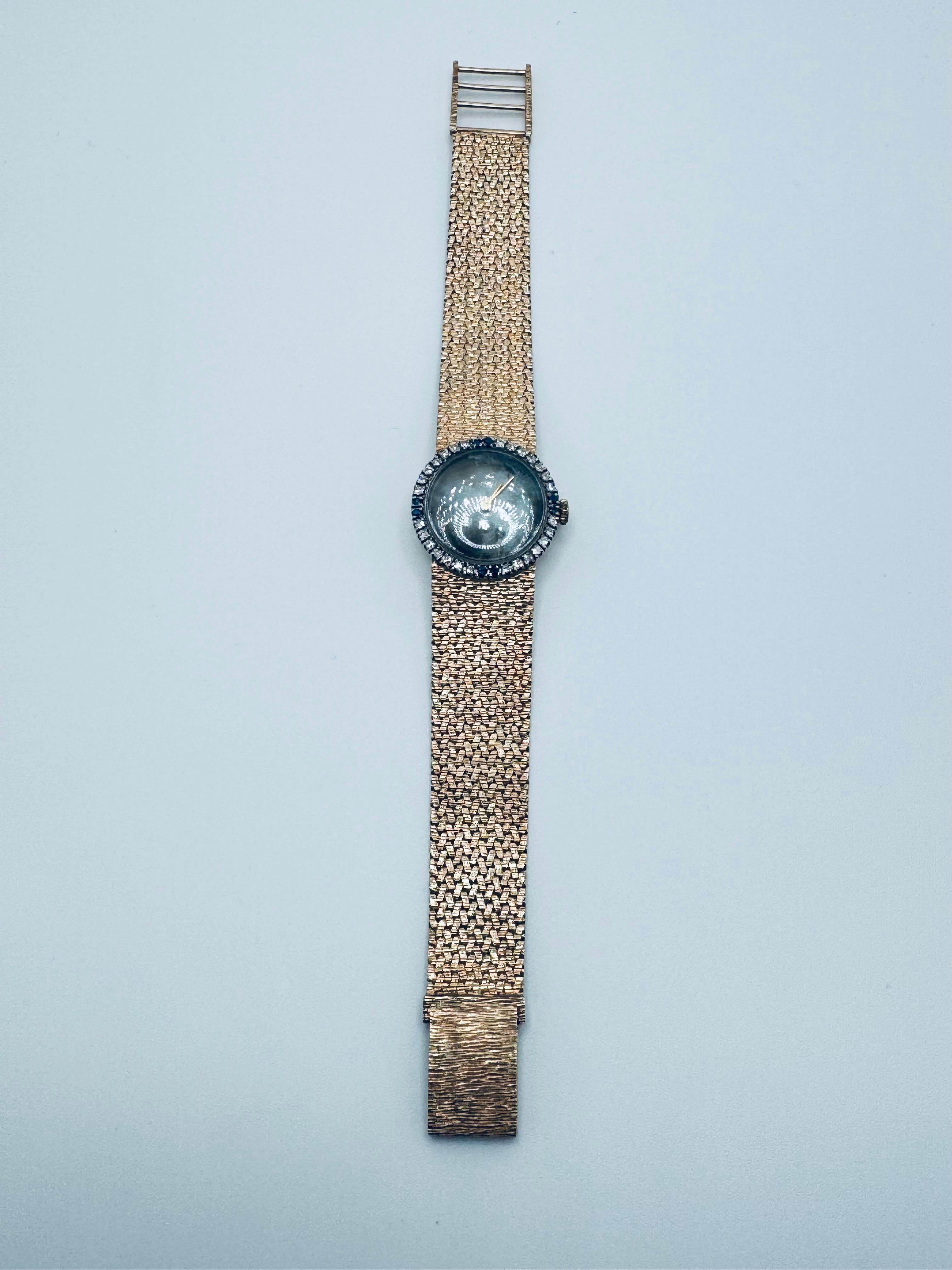 This beautiful, sophisticated 14KT Mattey Tissot Lids Watch, model MT14K #1367, is crafted in rich yellow gold with elegant gemstone accents. The watch features 8 round blue sapphires that bring a vivid, luxurious touch, beautifully paired with 28