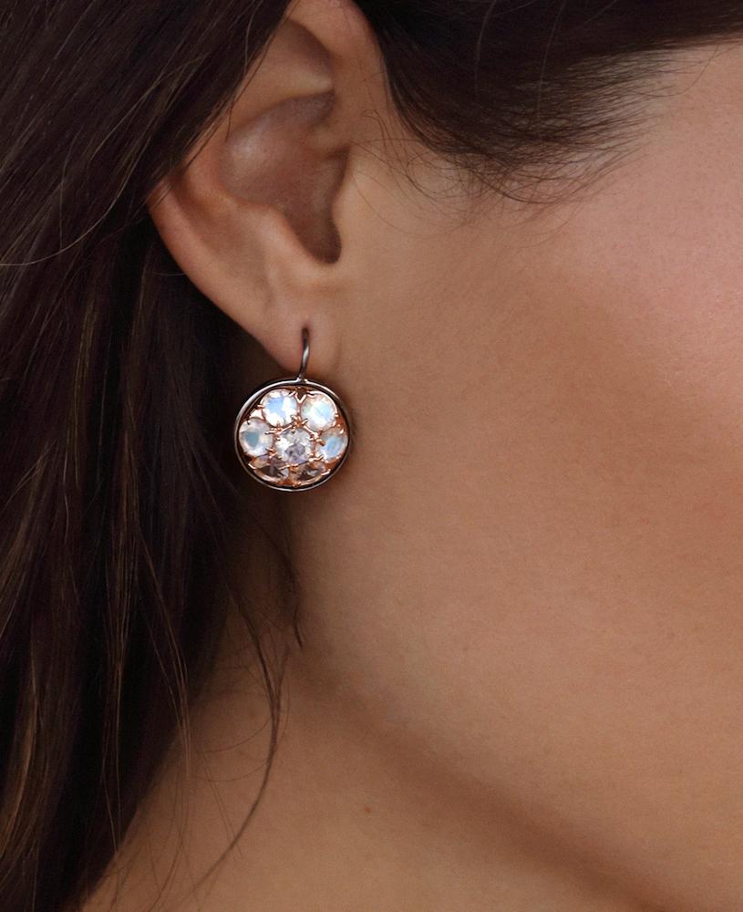 The Seven Moons is a dynamic hook earring that scales to the ear and sends light of the blue moonstones in all directions. It has a 14kt rose gold setting inlaid in the sterling silver backing which incorporates the A&A logo. 

14kt rose