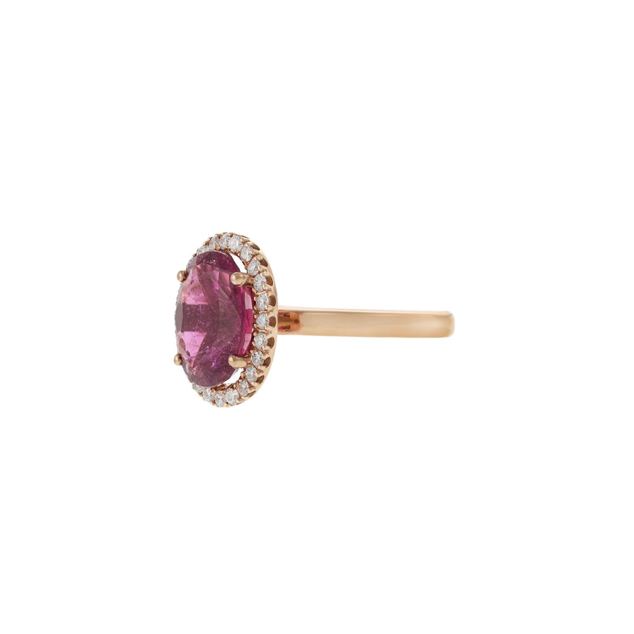 This striking ring features a vivid 3.57-carat oval cut pink rubellite, radiating warmth and color from its 14KT rose gold setting. Surrounding the center stone is a halo of sparkling round cut diamonds totaling 0.36 carats, graded G-VS for