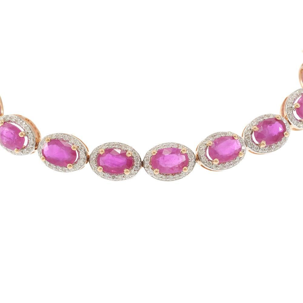 Expression radieuse de l'élégance, ce bracelet en or rose 14KT présente une rangée ininterrompue de rubis vifs de taille ovale totalisant 11,25 carats. Chaque rubis est entouré d'un délicat halo de diamants ronds de taille brillant, pesant