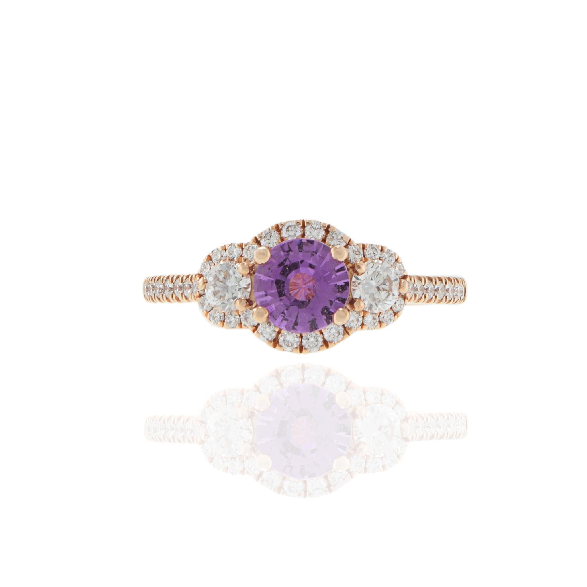 Soft color meets timeless sparkle in this 14KT rose gold ring, featuring a vibrant 0.83 carat round pink sapphire framed by 0.53 carats total weight of round brilliant diamonds. The three-stone-inspired silhouette is elevated with delicate diamond