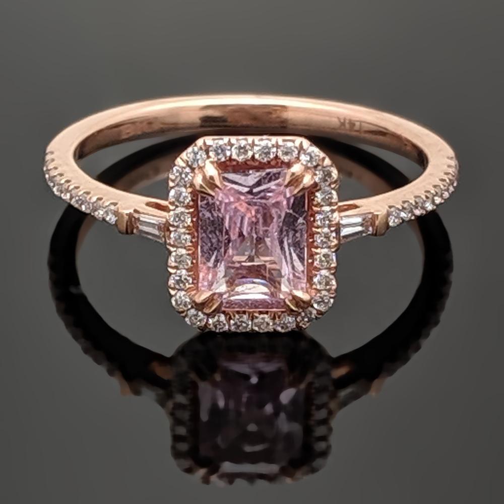 A 14kt rose gold ring featuring a dazzling pink sapphire estimated at 0.99ct accented with baguettes and a halo of round brilliant diamonds estimated at  0.23cttw. Estimated weight of gold is 1 gr. 

We will size it for you.

