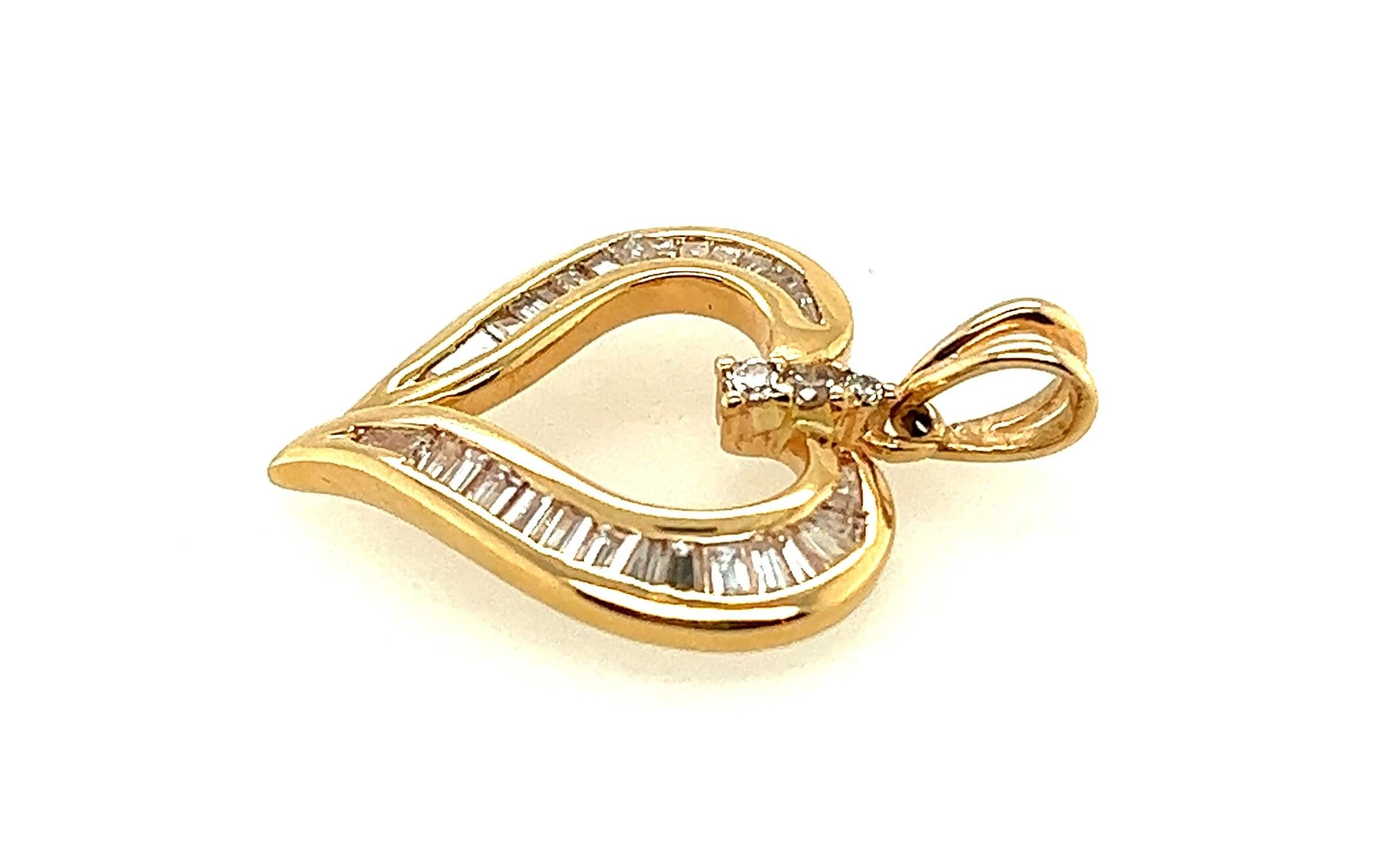 14kt yellow gold diamond heart pendant with approximately 1.00 carat of prong set round brilliant and channel set baguette cut diamonds. The diamonds appear to possess an average of H-I color and SI1-SI2 clarity.  

The pendant measures 1 and 1/16