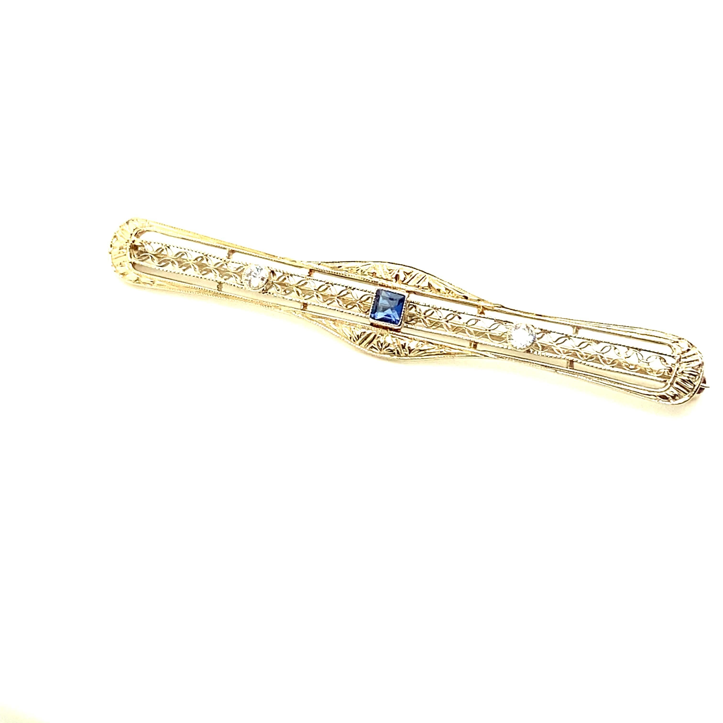 Completely original and completely gorgeous 14kt white and yellow gold Art Deco Bar pin. The pin contains one center square shaped sapphire and two round diamonds (one on either side of the center sapphire). 

The pin measures 2.50 inches long by