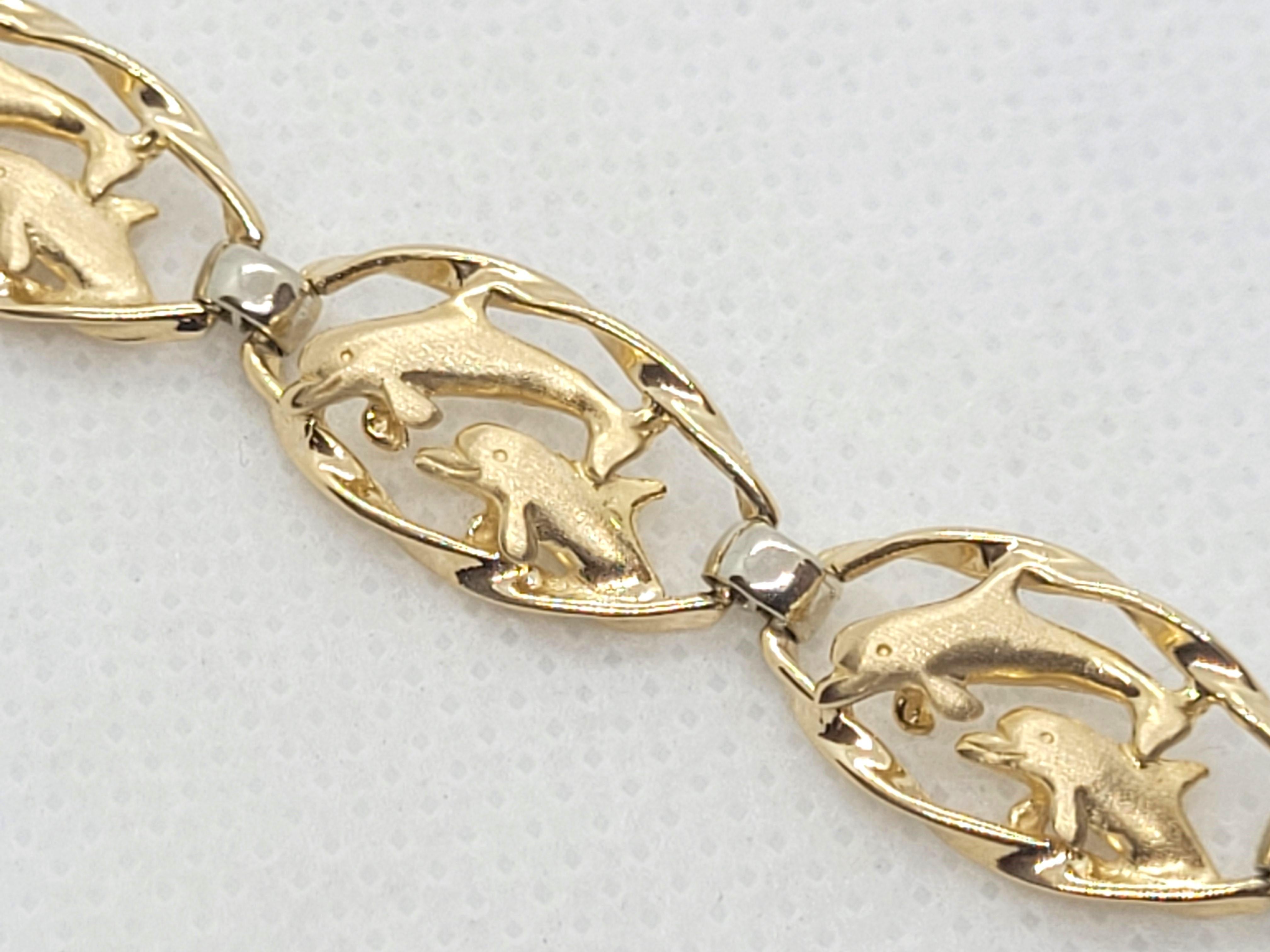 Lovely 14kt two-tone dolphin 6.5-inch bracelet, 9.5mm wide, 2.4mm thick, satin/high polish finish, 11.2 grams weight (stamped 14K), and secured with a push-in clasp w/ double safety latch. The small links are white gold and the large links have a