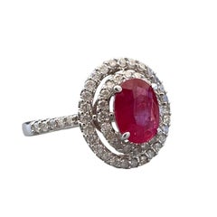 Anillo de cóctel de oro blanco de 14 quilates con un rubí ovalado de 1,40 quilates y halo de diamantes dobles
