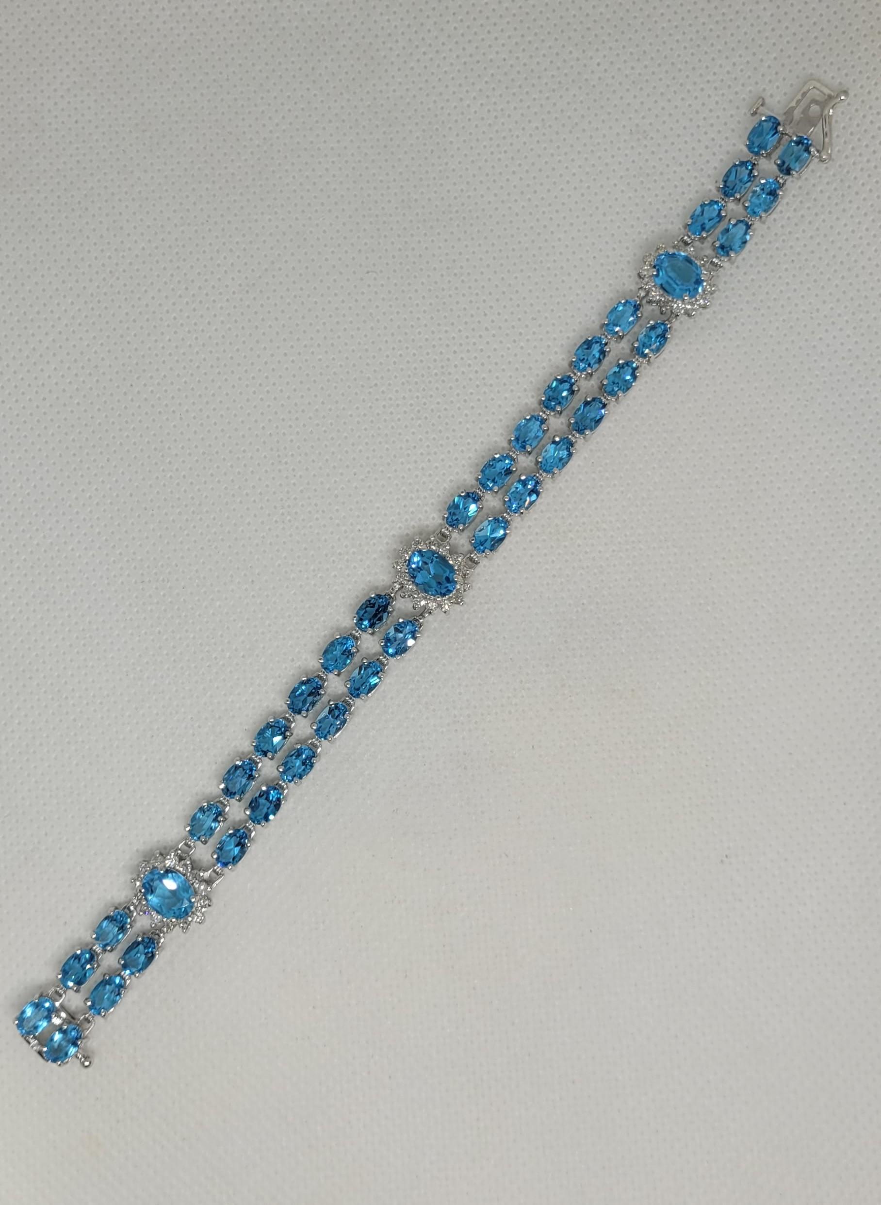 This stunning 14kt white gold bracelet features 39 oval-shaped, natural blue topaz gemstones with a total weight of 50.50 carats. The blue topaz has a medium Swiss blue color with an even and vivid tone, along with a very good cut and polish, making