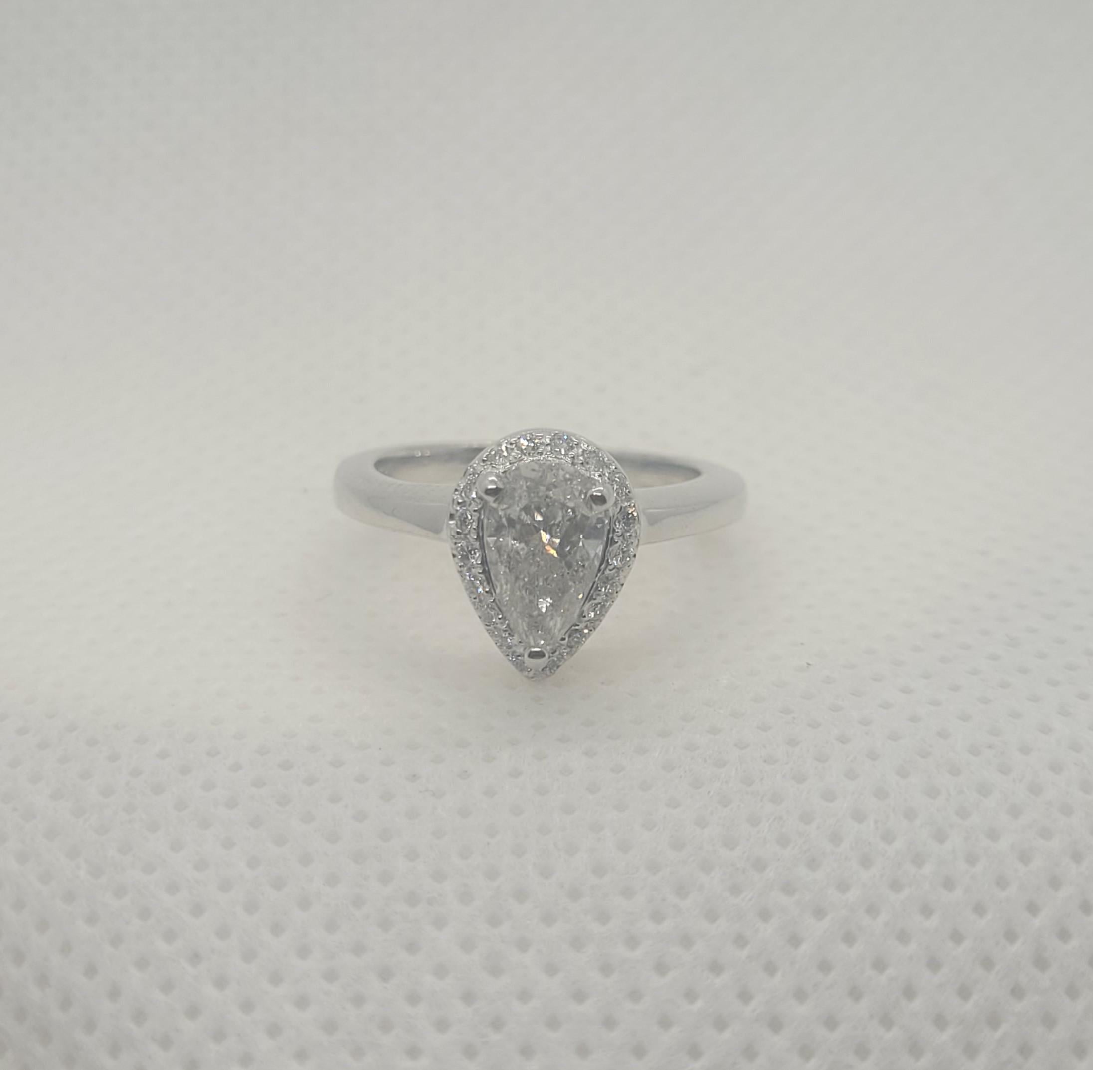 Lovely 14kt white gold ring with a .80ct pear-shaped diamond (approx. weight) surrounded by an 18-round brilliant diamond halo. The center diamond is G in color and I2 in clarity, surrounded by 18 round brilliant diamonds of approximately .25cttw.