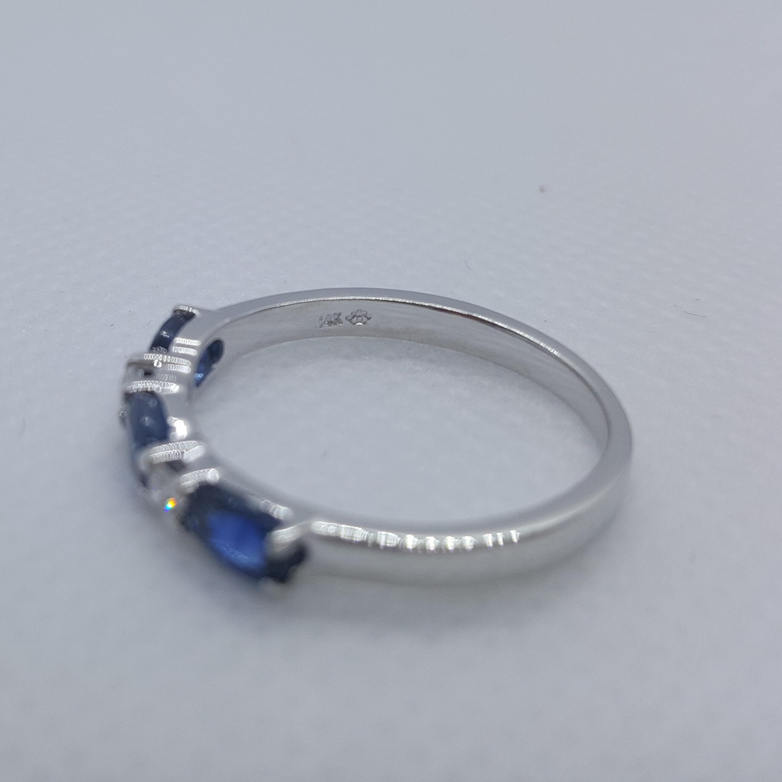 Schöner 14kt Weißgoldring mit 3 feinen blauen ovalen Saphiren von ungefähr .80cttw und 2 runden Diamanten von .05 cttw. Der Ring ist 2,3 mm an der Spitze verjüngt sich auf 2 mm an der Basis und Größe 7; gestempelt 14kt und wiegt 7,3 Gramm. Insgesamt