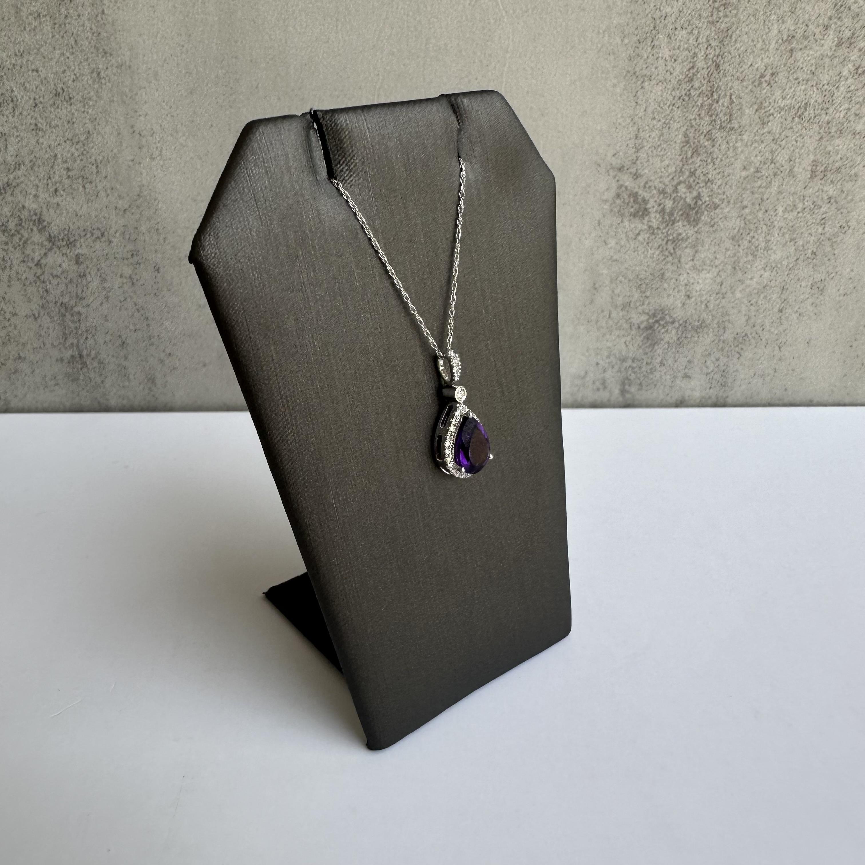 Enhance your jewelry collection with this exquisite 14kt White Gold Amethyst and Diamond Necklace. Featuring a 9x6mm purple amethyst and 0.17 carats of GH SI natural single cut diamonds, this necklace combines timeless beauty with modern elegance,
