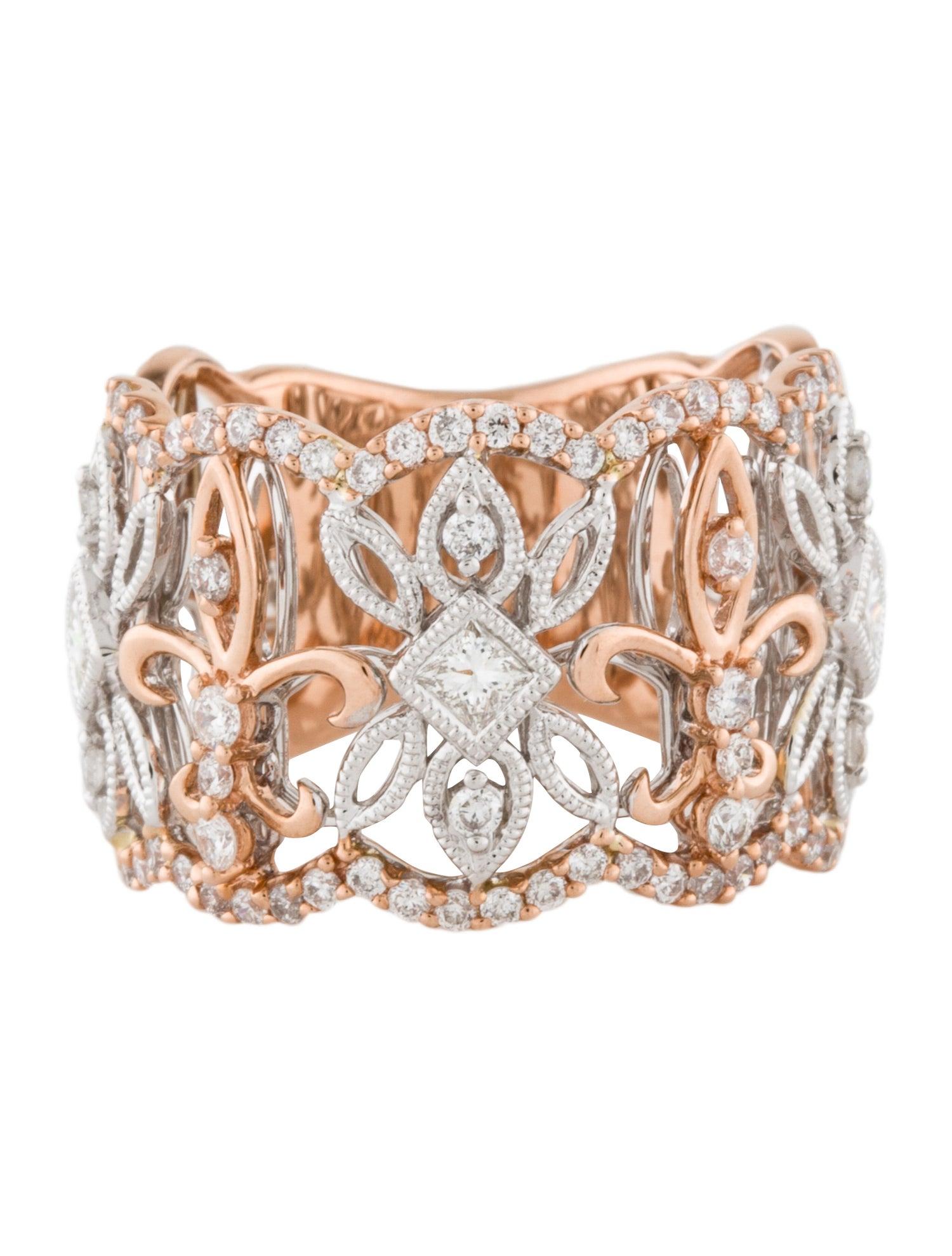 A beautiful 14Kt rose and white gold diamond band featuring 0.46 carats of round brilliant cut diamonds and 0.34 carats of princess cut diamonds. There is a fleur-de-lis motif adorning the band. There are 3 princess cut diamonds and 64 round