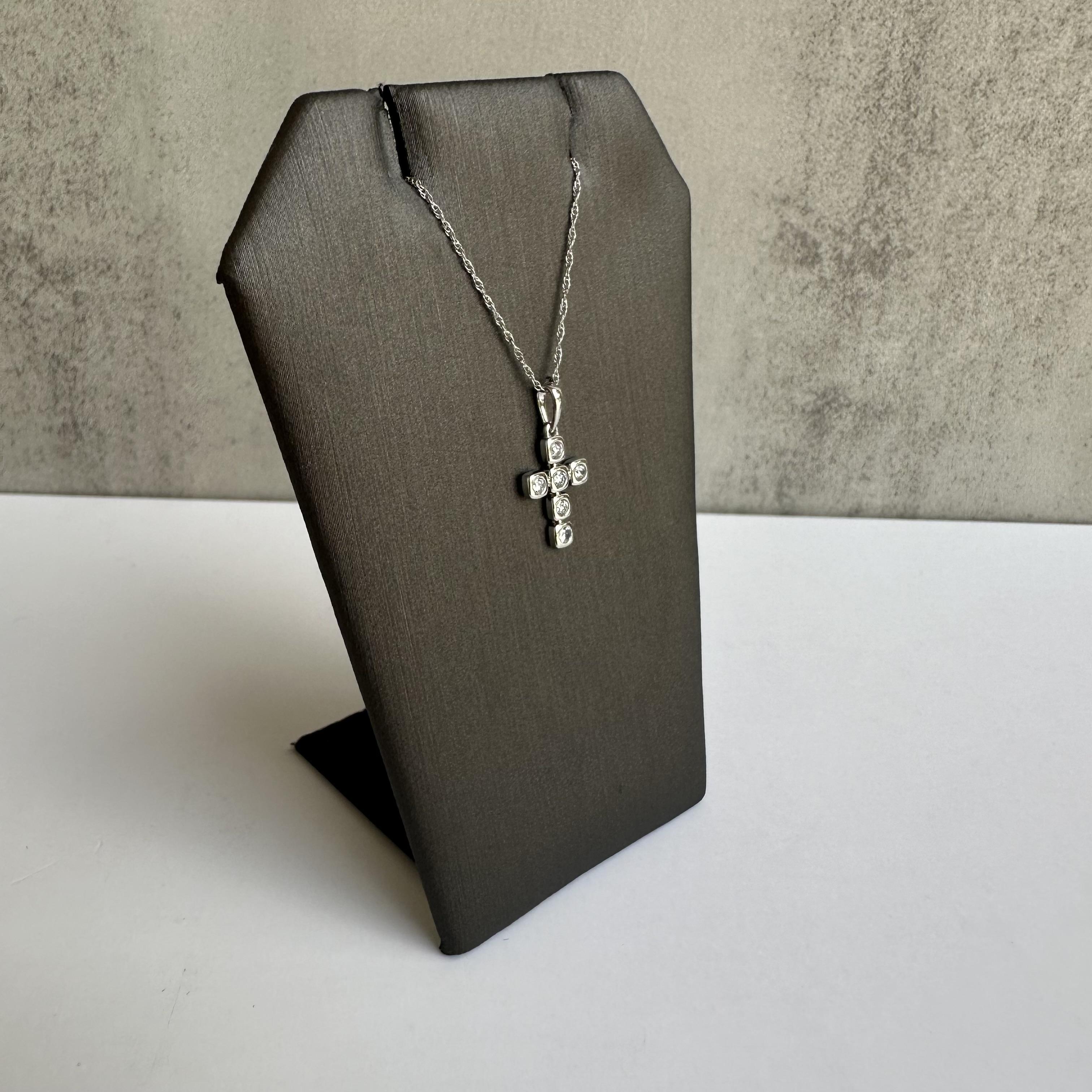 Erweitern Sie Ihre Schmucksammlung mit dieser eleganten, diamantbesetzten Kreuz-Halskette aus 14 Karat Weißgold. Dieses wunderschöne Schmuckstück mit 0,16 Karat runden Naturdiamanten GH I1 bietet ein subtiles Funkeln und zeitlose Eleganz und ist