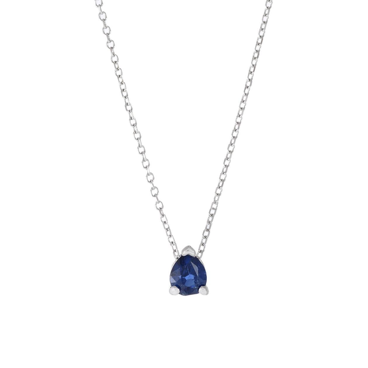 This 14KT white gold pendant necklace is a dainty and elegant piece of jewelry, featuring a .35-carat pear-cut blue sapphire at its center. The pendant is suspended from a fixed 14KT white gold cable chain, creating a simple and sophisticated