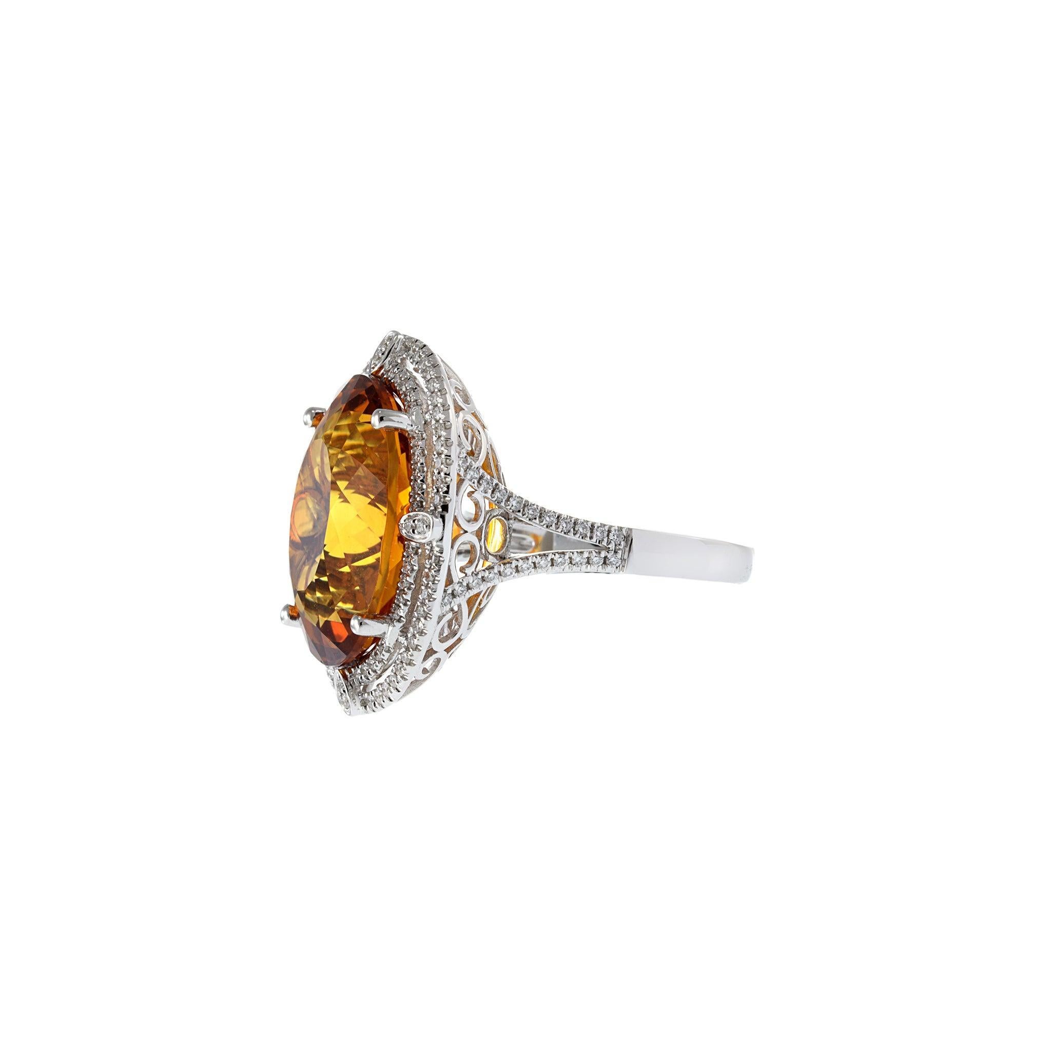 Questo anello da cocktail in oro bianco 14KT, che emana calore e brillantezza, presenta un accattivante citrino ovale da 13,87 carati, dai colori intensi e pieni di fuoco. La vibrante pietra centrale è incorniciata da un lussuoso doppio alone di
