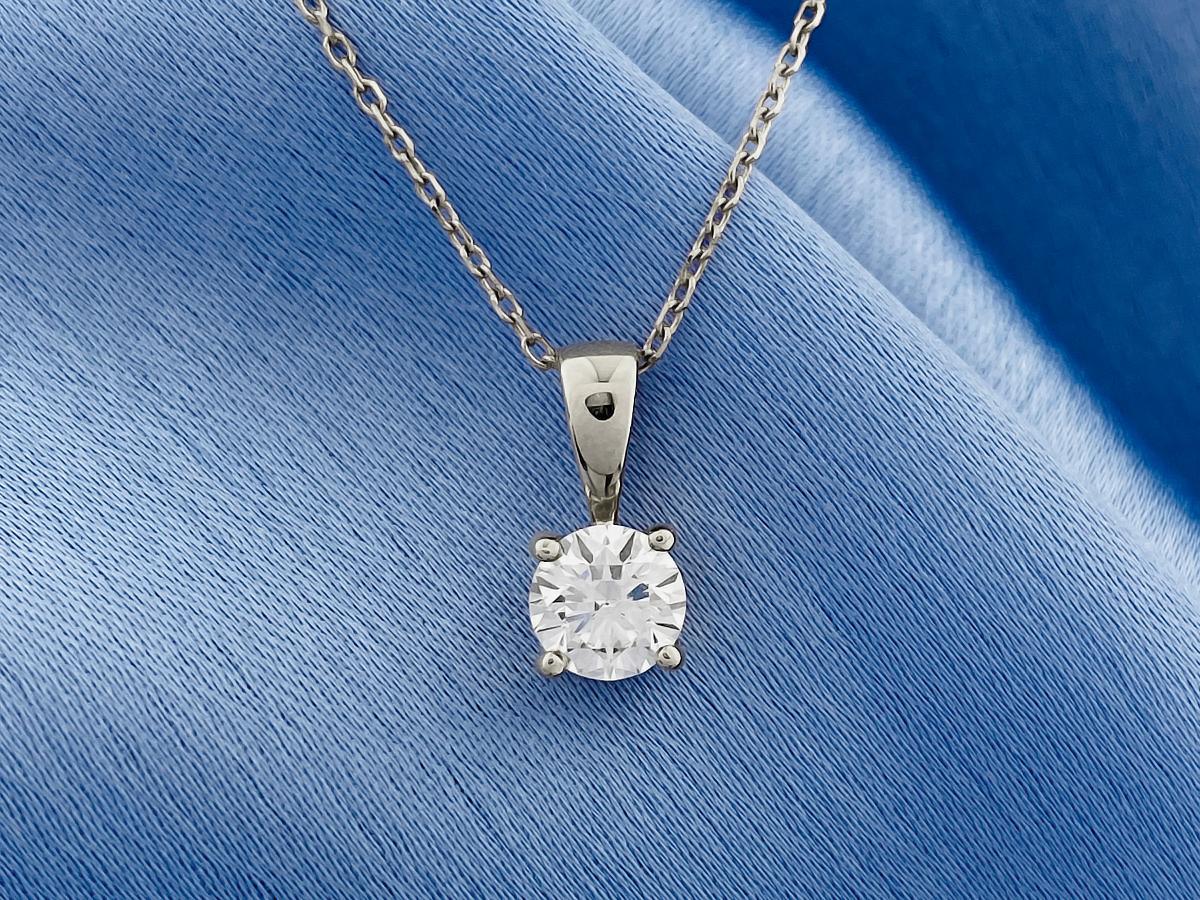 Questo classico ciondolo solitario offre un design minimalista ed elegante, perfetto da indossare ogni giorno o come regalo senza tempo. Presenta un singolo diamante brillante di taglio rotondo, tenuto saldamente in una montatura a cesto a quattro