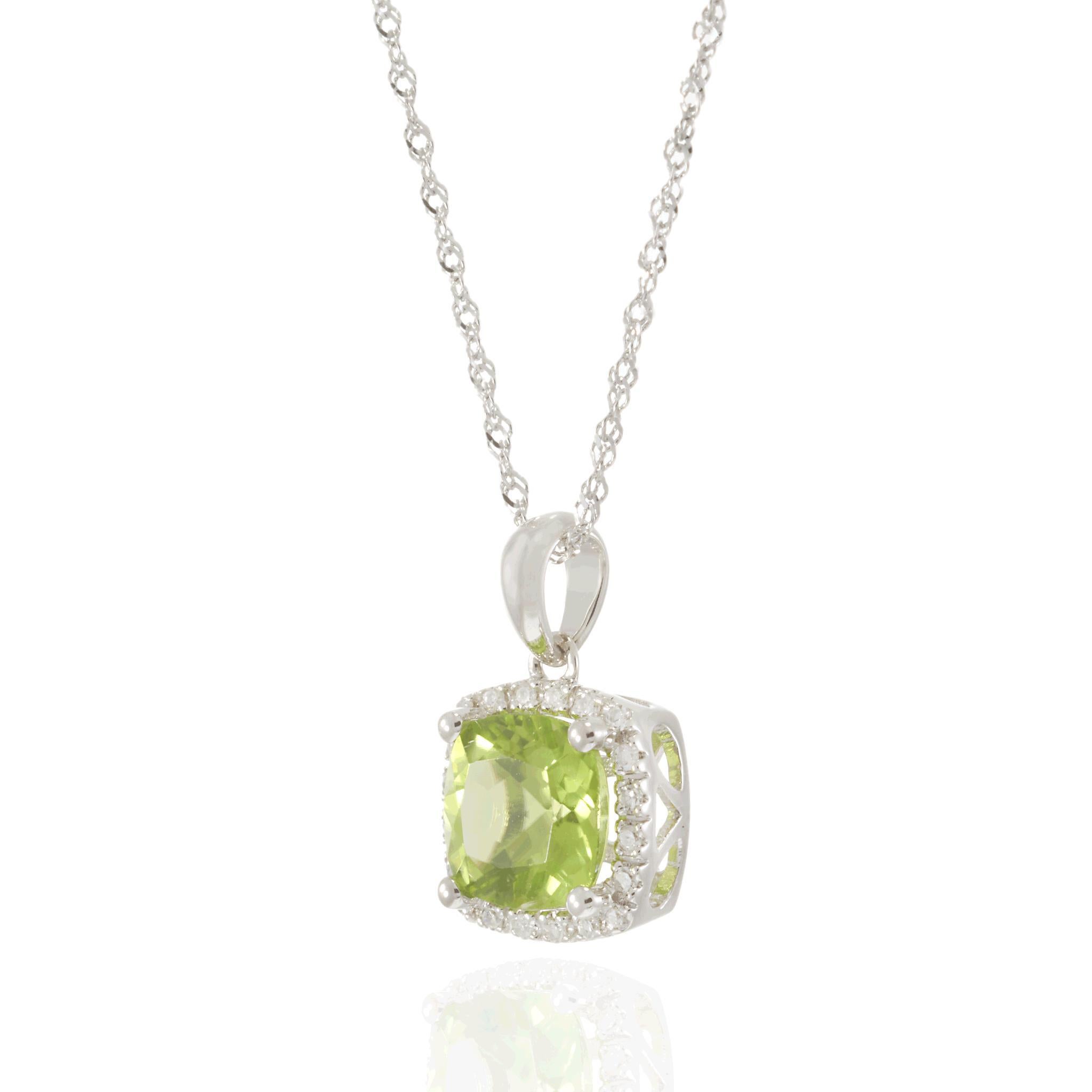 Elegant avec une touche de modernité, ce collier en or blanc 14 carats présente un superbe péridot taille coussin pesant 1,54 carats, encadré par un halo étincelant de 0,07 carats de diamants brillants. La pierre précieuse d'un vert éclatant se