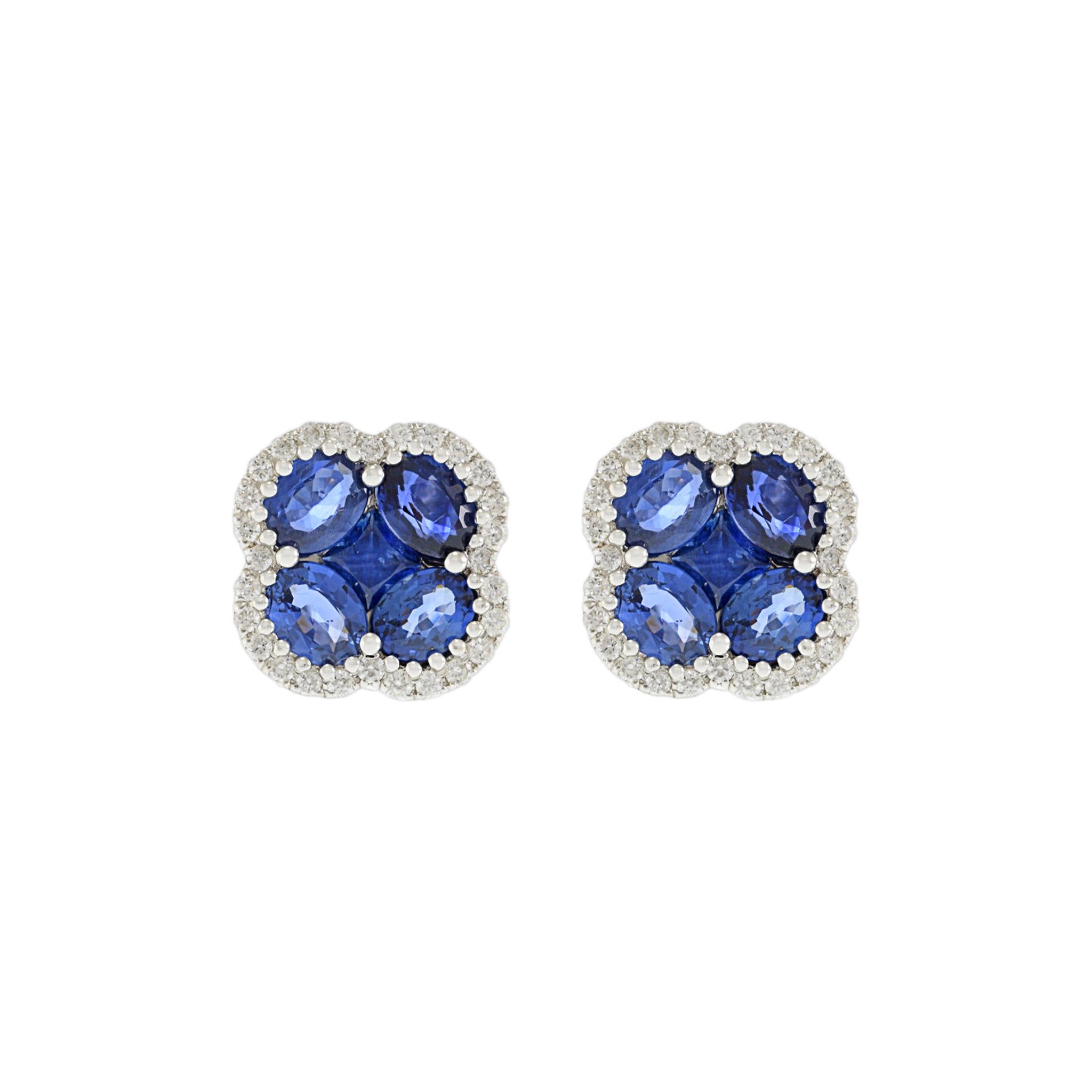 14KT White Gold Flower Clover Earrings with Round Cut Diamonds and Blue Sapphires. These stunning earrings feature a total of 0.26 carats of G-VS round cut diamonds and 2.58 carats of blue sapphires in oval and princess cuts. Crafted from luxurious