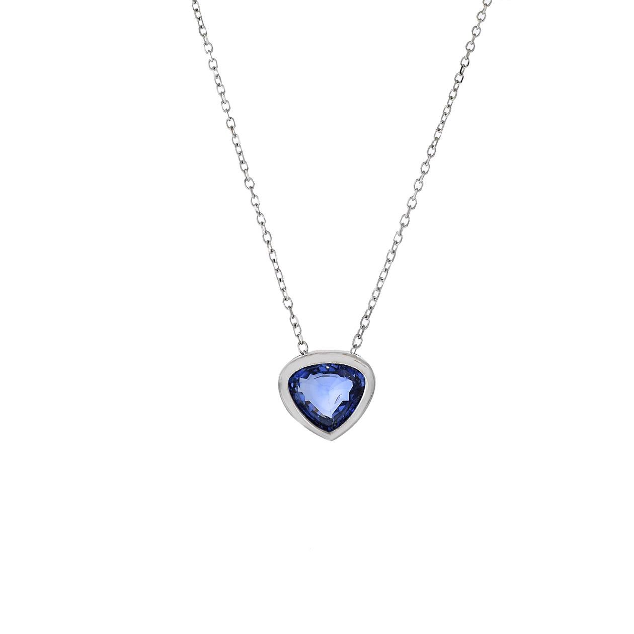 Ce collier pendentif en or blanc 14KT est un bijou élégant et minimaliste, mettant en valeur un saphir bleu authentique avec une coupe triangulaire unique. Le saphir pèse 0,70 carat et est solidement serti dans une lunette, ce qui ajoute à la