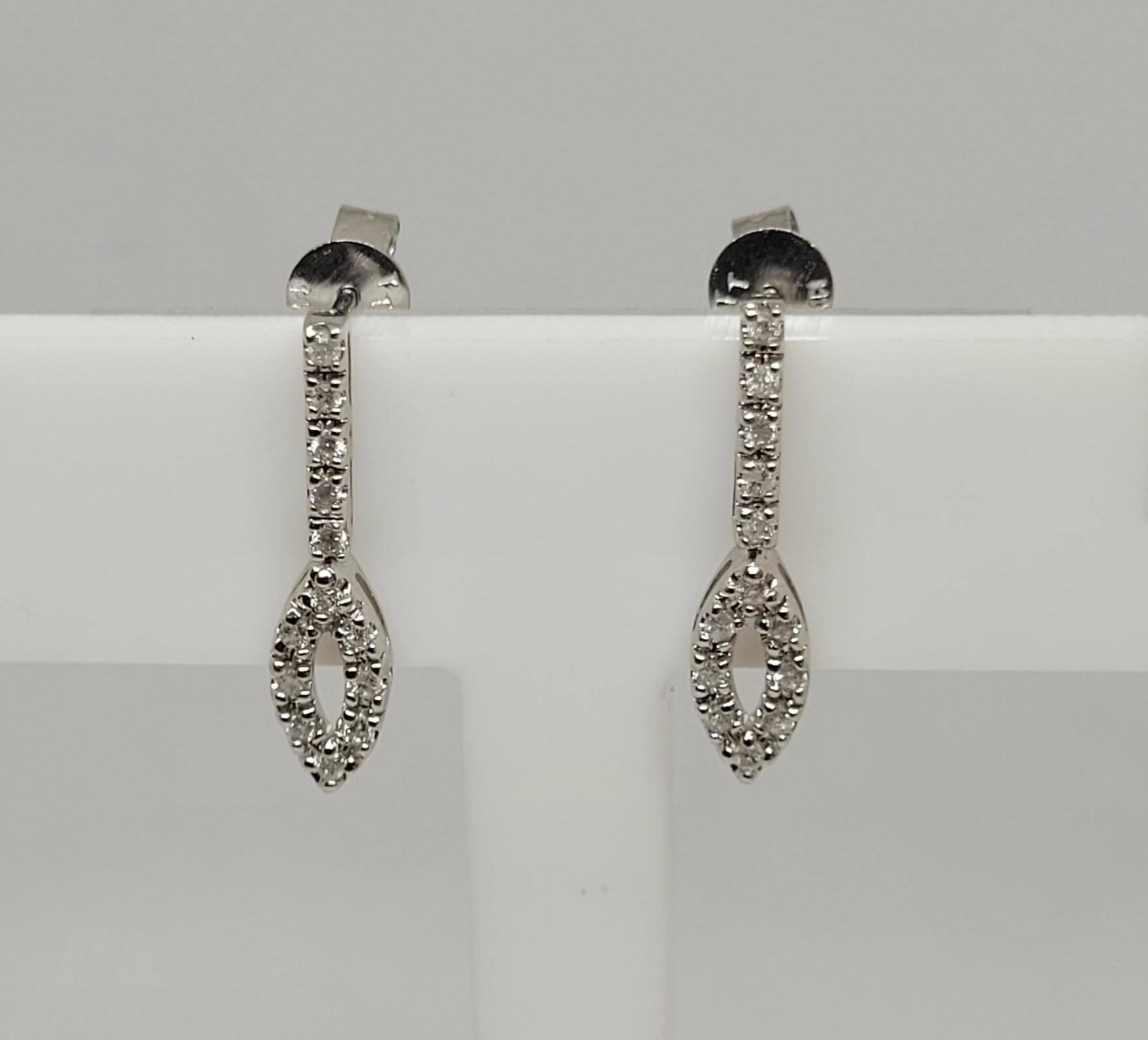Elegant 14kt white gold earrings with 26 diamonds of approximately .26cttw; the diamonds are commercial-grade, G/H in color, and I clarity. The diamonds are set in a prong setting that is 1.88 grams for both earrings, stamped 858 14kt, and secured