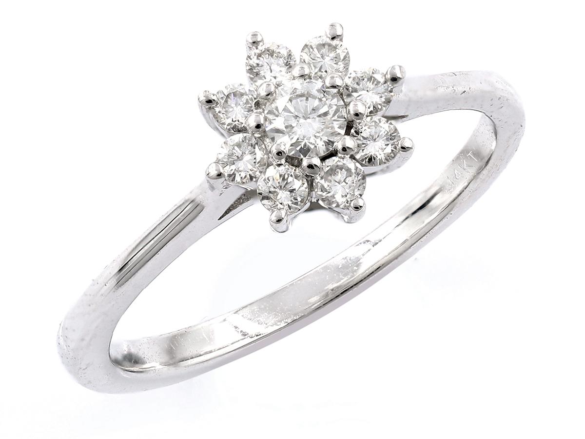 Das Herzstück des Rings ist ein Cluster aus runden Brillanten, die in einem Blumen- oder Gänseblümchenmotiv angeordnet sind. Diese Cluster-Fassung erweckt die Illusion eines größeren, einzelnen Steins und maximiert das Funkeln und die Brillanz. Das