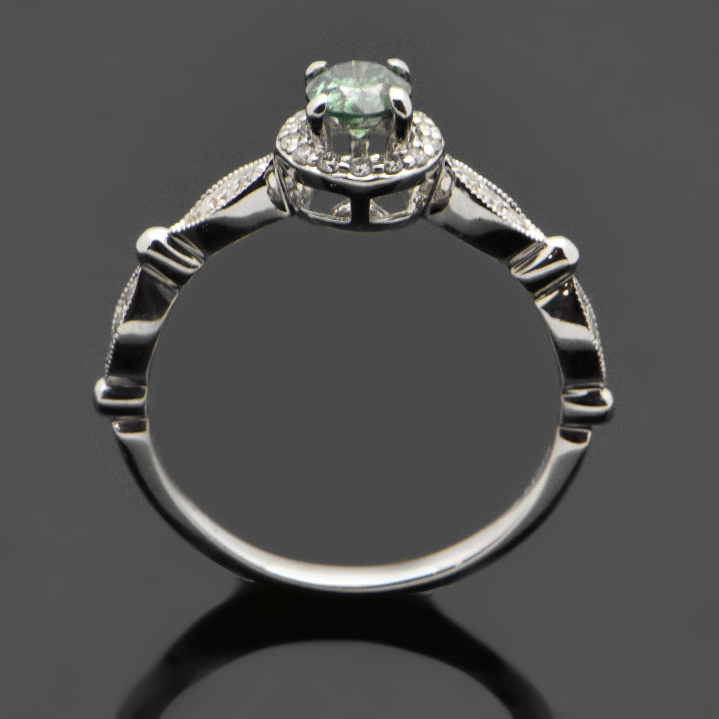 This 14kt white gold ring features a brilliant-cut green diamond with an estimated weight at 0.35ct. The green diamond is surrounded by diamonds and has diamond accents down the sides of the shank with an estimated 0.16cttw. Estimated weight of gold