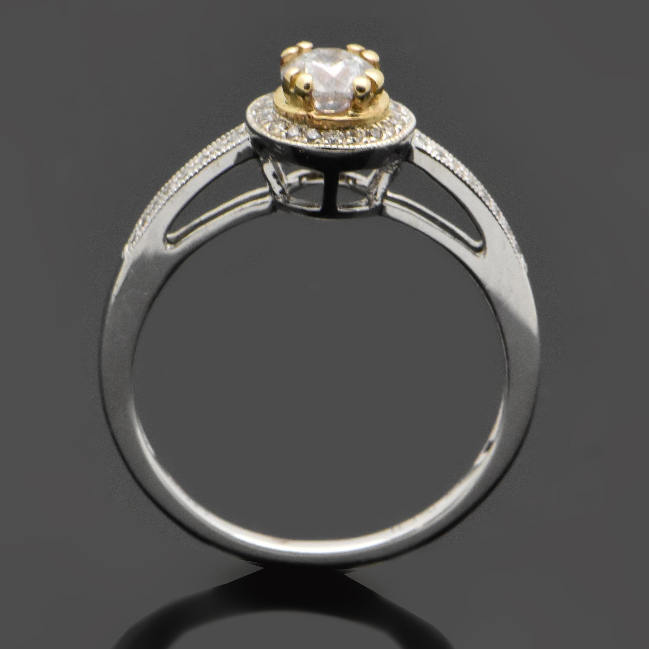 This ring features a 14kt white gold band and a center diamond at an estimated weight of 0.36ct in a yellow gold setting with double prongs. Diamonds in halo and down each shank are an estimated 0.11 cttw. Estimated weight of gold is 2 gr. 

We will