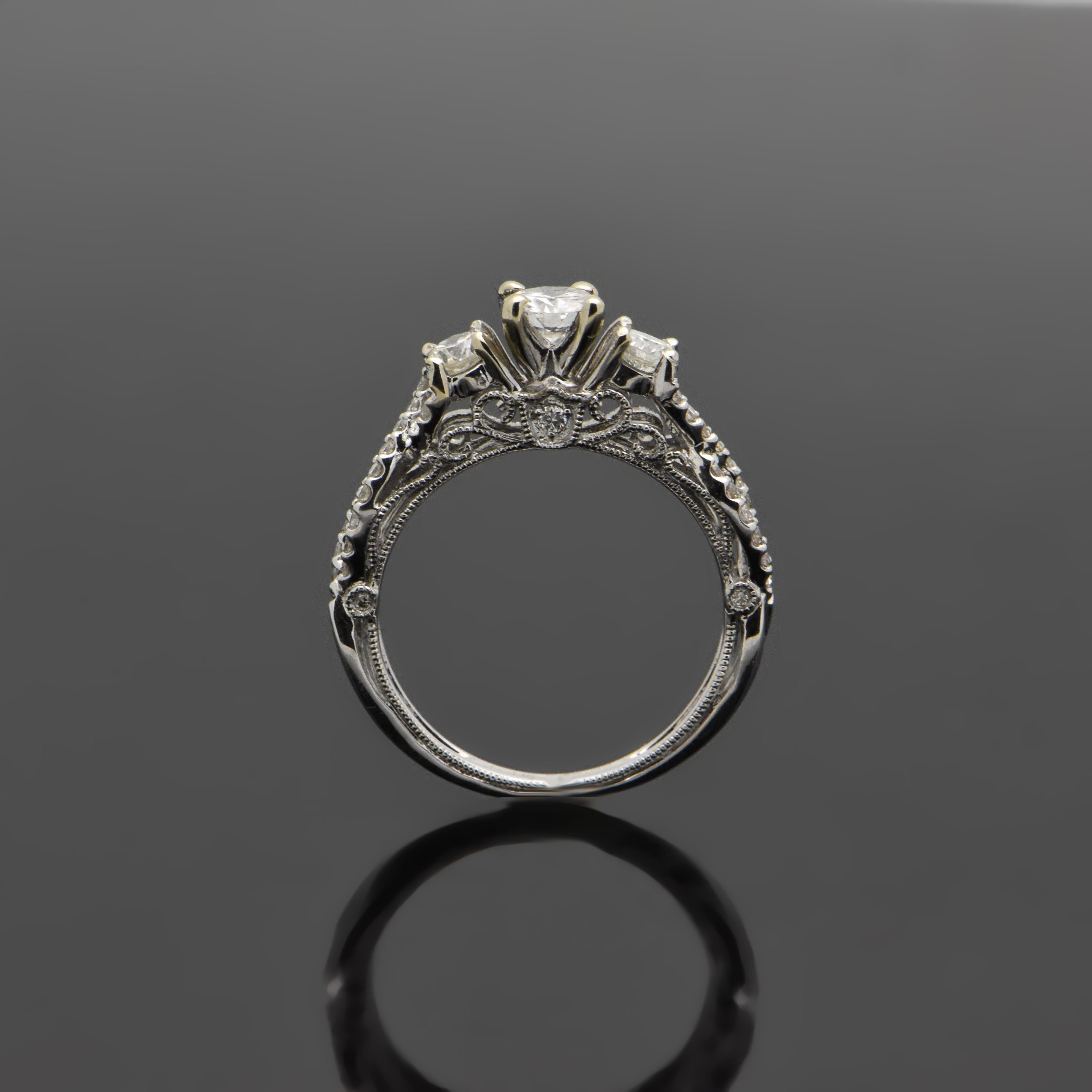 A 14kt White gold ring with a center diamond estimated at 0.33ct. and surrounding diamonds estimated at 0.56cttw. The setting features an infinity design with beautiful miligran details. Estimated weight of gold is 3 gr. 

We will size it for you.


