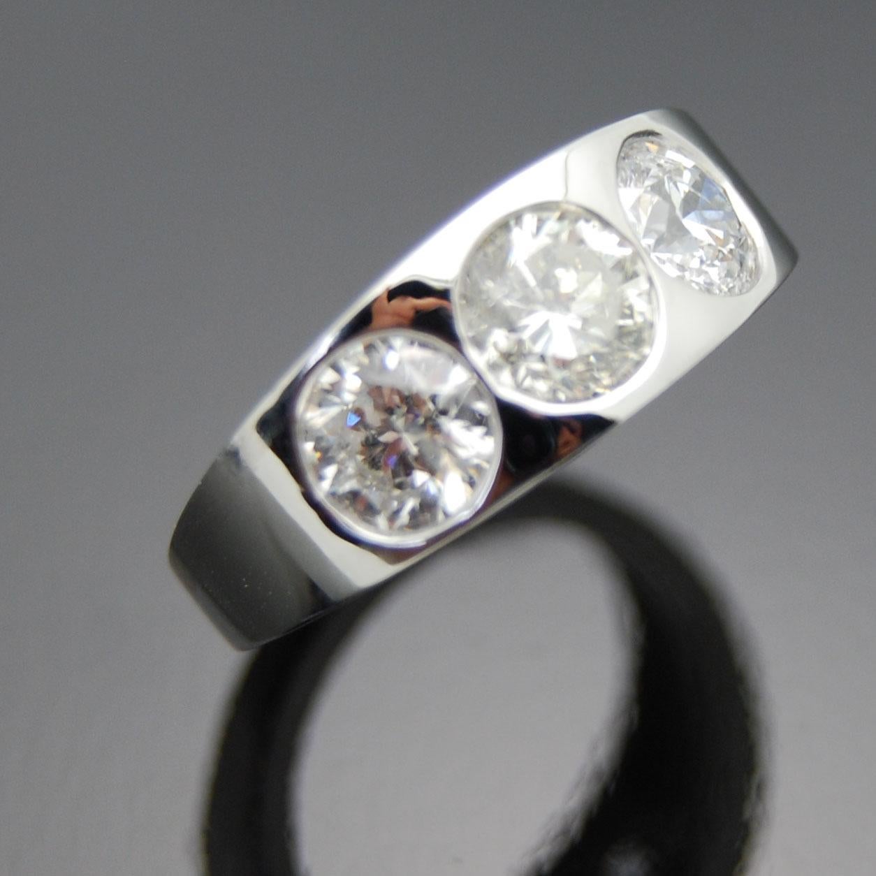 14kt White Gold Diamonds Ring. This low profile ring features a trio of round brilliant cut diamonds in a delicately tapered white gold band.

This item is a custom order only. Price is for the ring setting only. The stone will be priced separately.