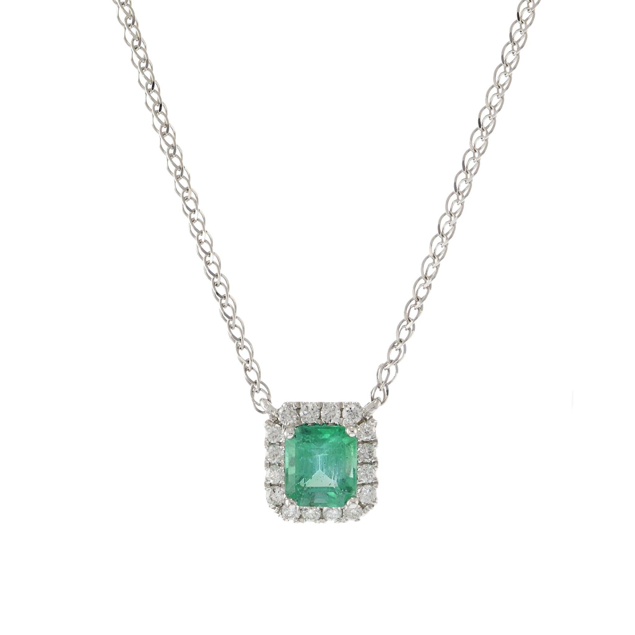 Questa raffinata collana presenta uno smeraldo da 0,47 carati, elegantemente incastonato in oro bianco 14KT. Il vibrante smeraldo è circondato da un'aureola di 0,12 carati di diamanti a taglio rotondo, che aggiungono un tocco di lucentezza ed