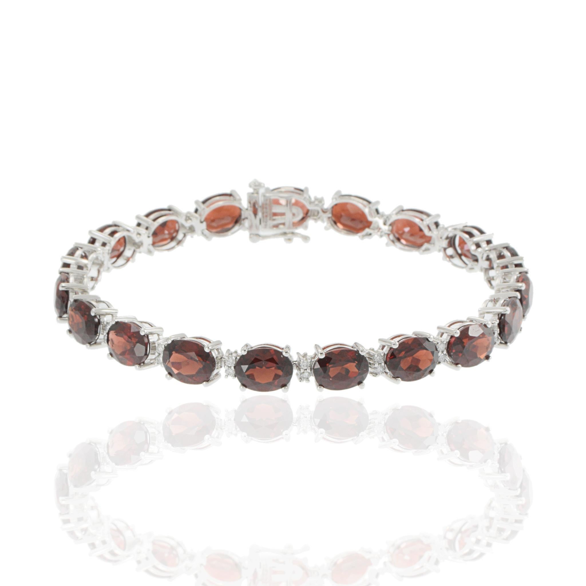 Dieses Armband aus 14-karätigem Weißgold hat einen kräftigen Farbton und eine zeitlose Form. Es zeigt eine luxuriöse Abfolge von ovalen, facettierten Granaten mit einem Gesamtgewicht von 32,96 Karat. Jeder der tiefroten Edelsteine ist zwischen