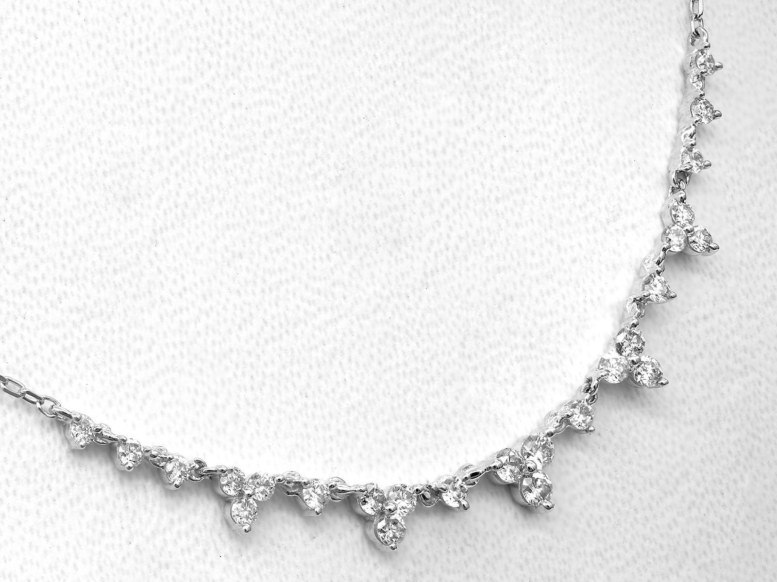 La collana ha un design minimalista ed elegante in cui piccoli diamanti rotondi sono incastonati l'uno vicino all'altro in una leggera curva verso l'alto. I diamanti sono graduati, cioè sono più piccoli alle estremità e più grandi al centro, creando