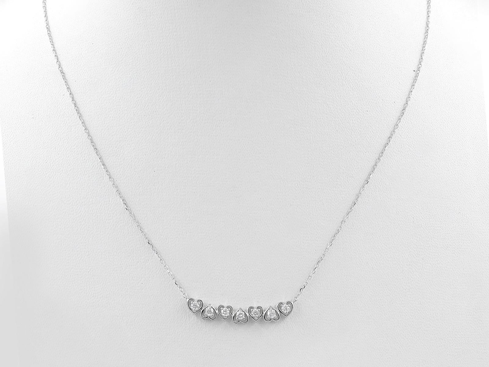 La collana presenta un'elegante e sottile curva di sette incastonature a forma di cuore, spesso chiamata 