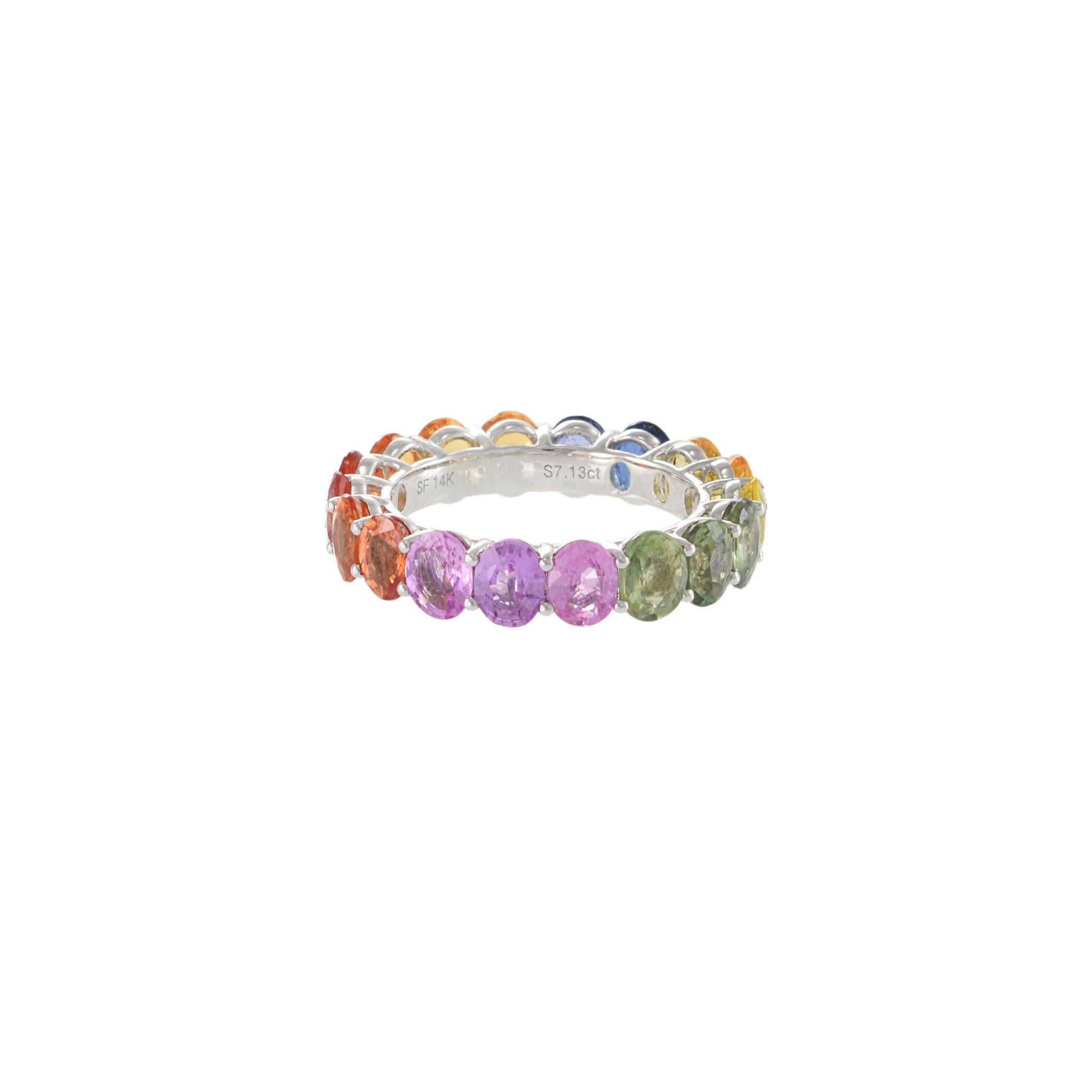 Beautifully crafted 14KT white gold eternity band set with 7.13CT-TW of oval cut Multi-colored sapphires. Size 5.75 US. Weight 4.1 gm.