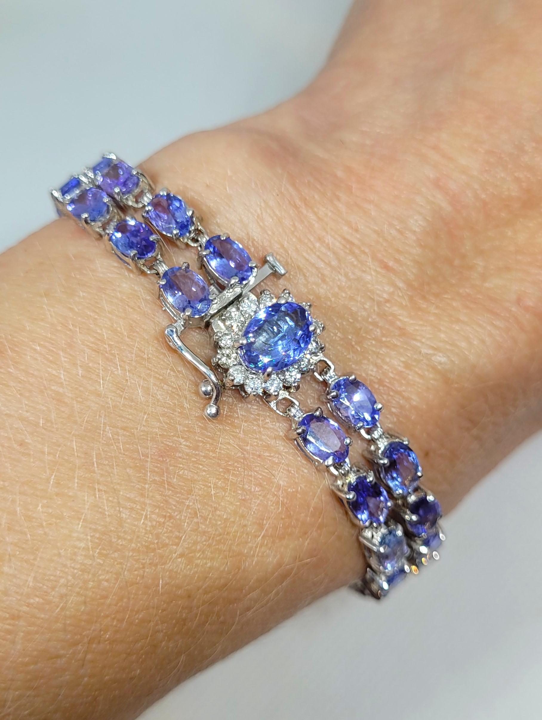 This stunning 14kt white gold bracelet features tanzanite and diamonds. It showcases 45 natural medium purple-blue tanzanites, totaling 22.35 carats, and 14 round brilliant diamonds, totaling 0.40 carats. The tanzanites are oval-shaped, uniform in