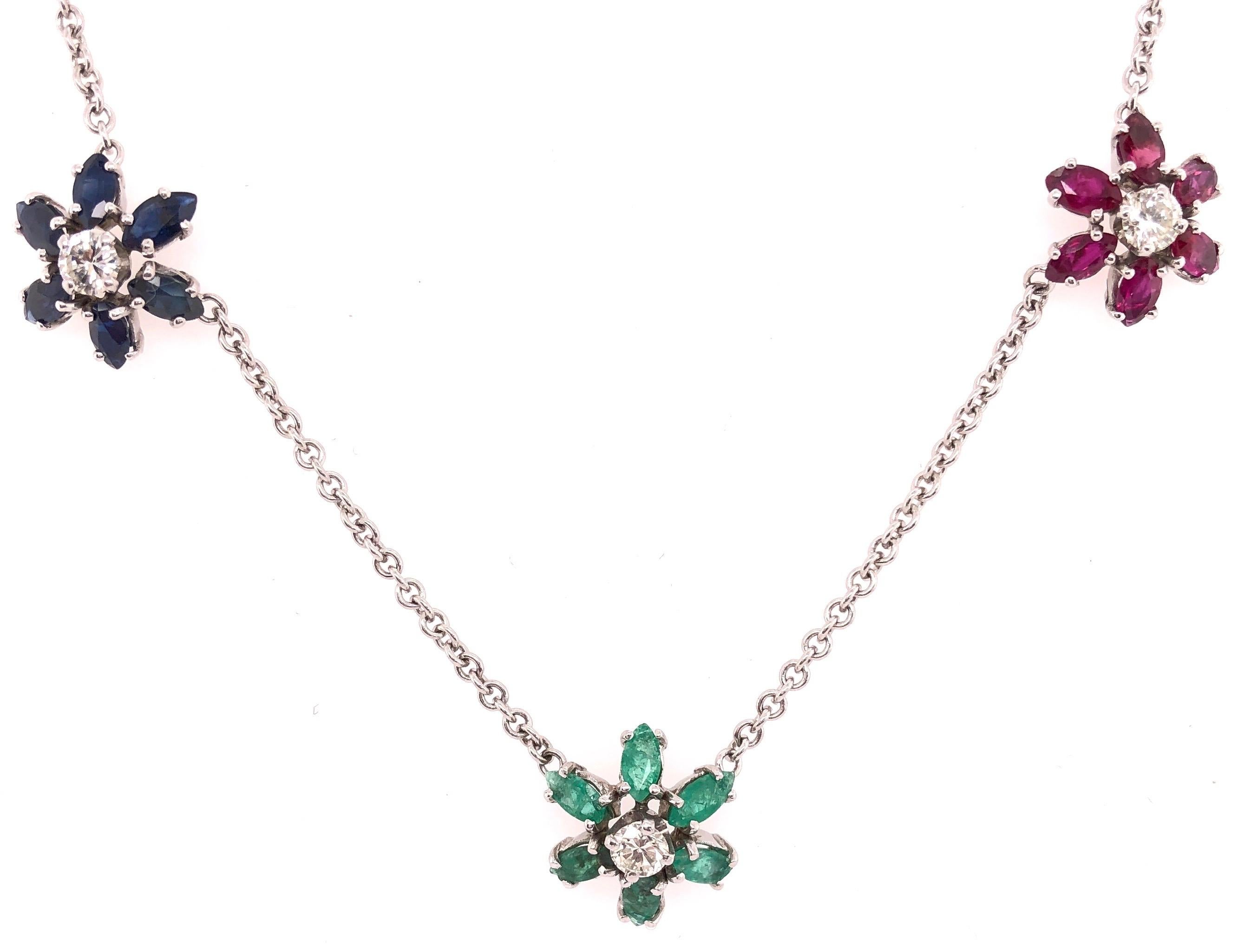 14 Kt White Gold Necklace with 3 Flowers In Ruby, 6 approx 1.50 Total Weight,  Sapphire, approx 1.50 Total Weight and  Emerald 1.50 Total Weight with
0.75 Round Total Diamond Weight. The necklace itself weighs 9 grams in total. 16 Inches. 